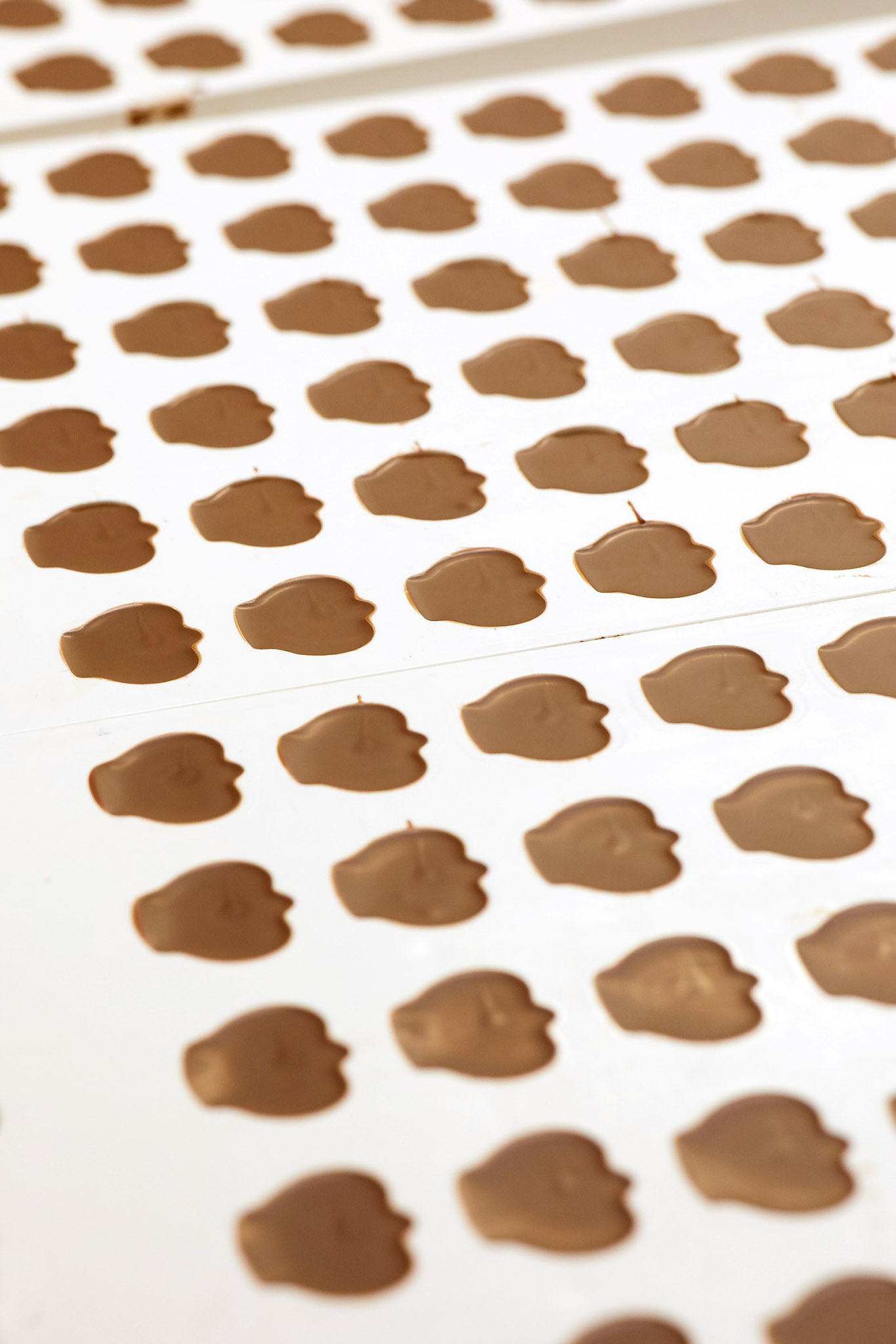 prestat white paper with rows of shaped chocolates evenly spaced
