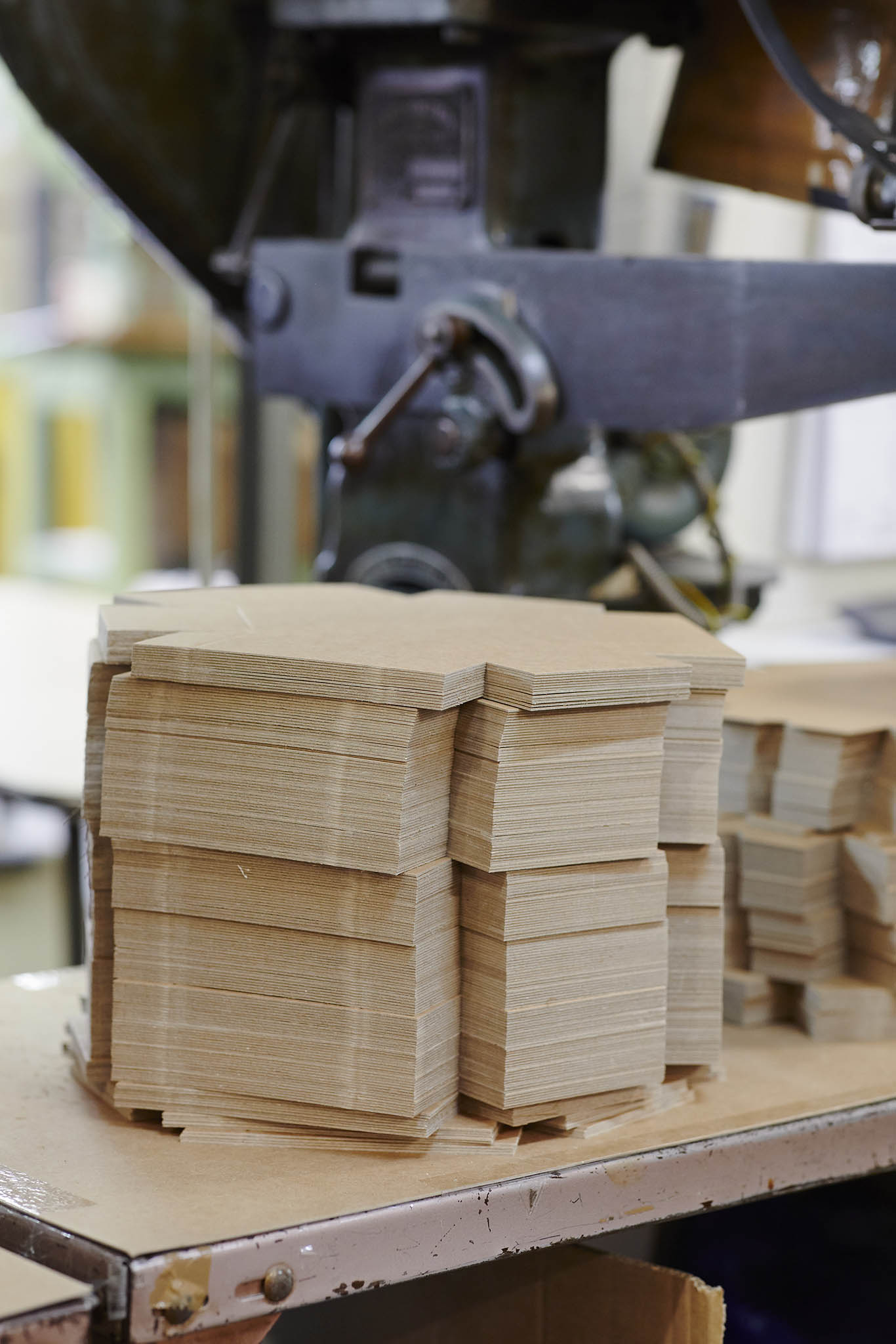 W MacCarthy & Sons stack of unfolded cardboard presentation boxes in front of large metal machine
