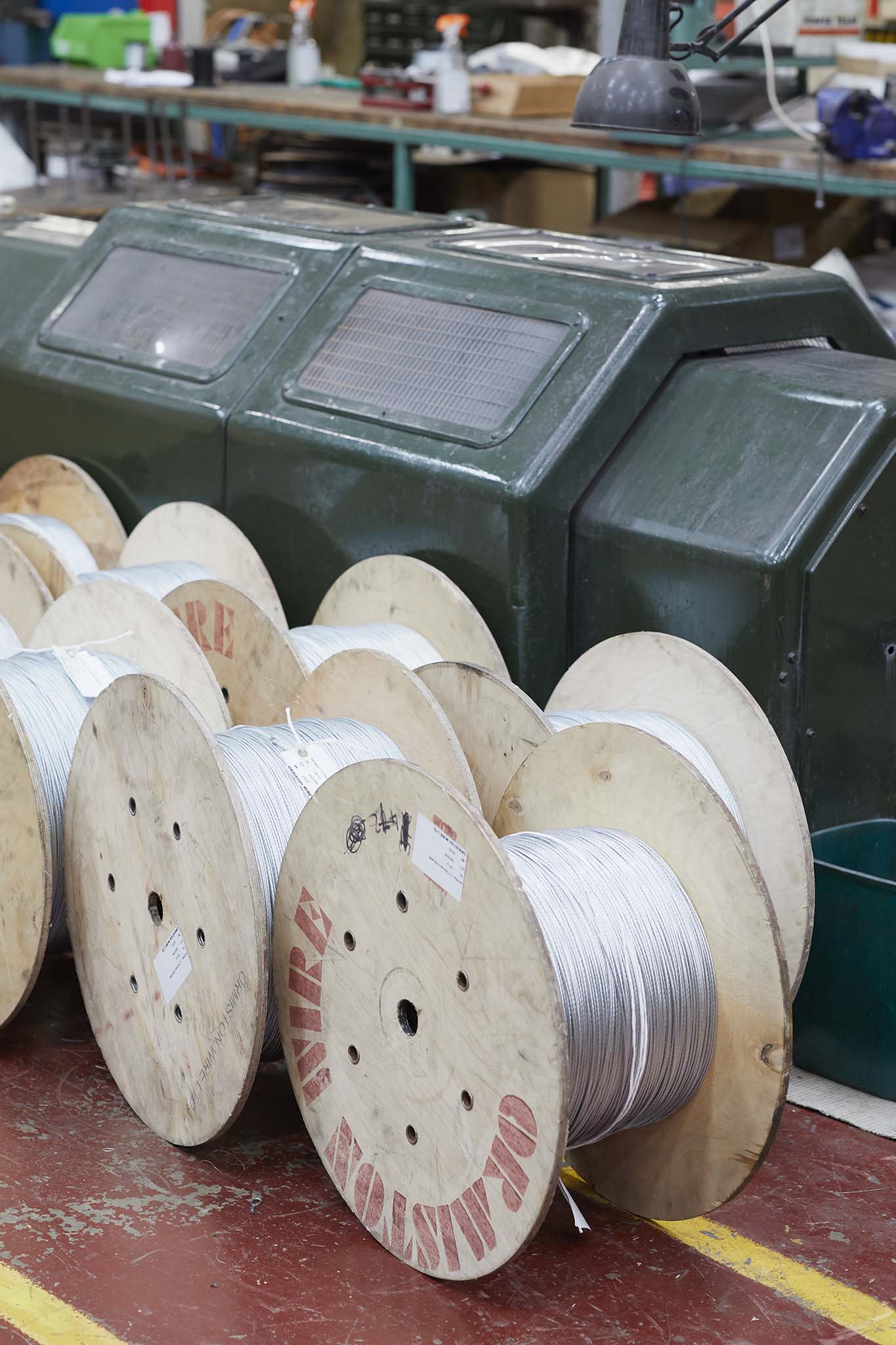 Ormiston Wire large rolls of silver metal wire on red factory floor green machinery in background