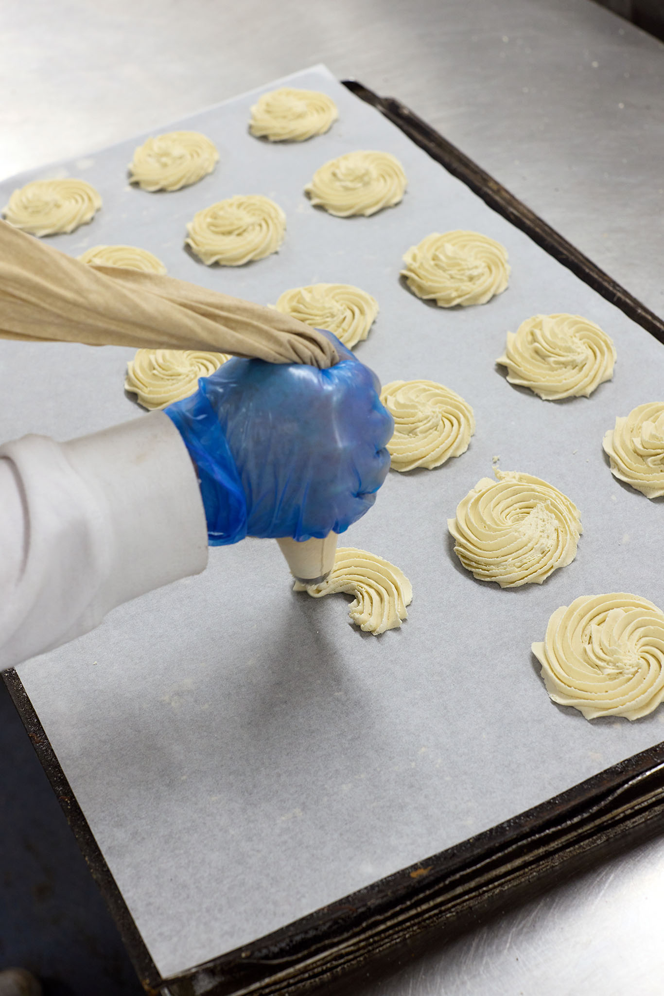Janes Pantry employees bakers in bakery piping mixture batter onto white sheet