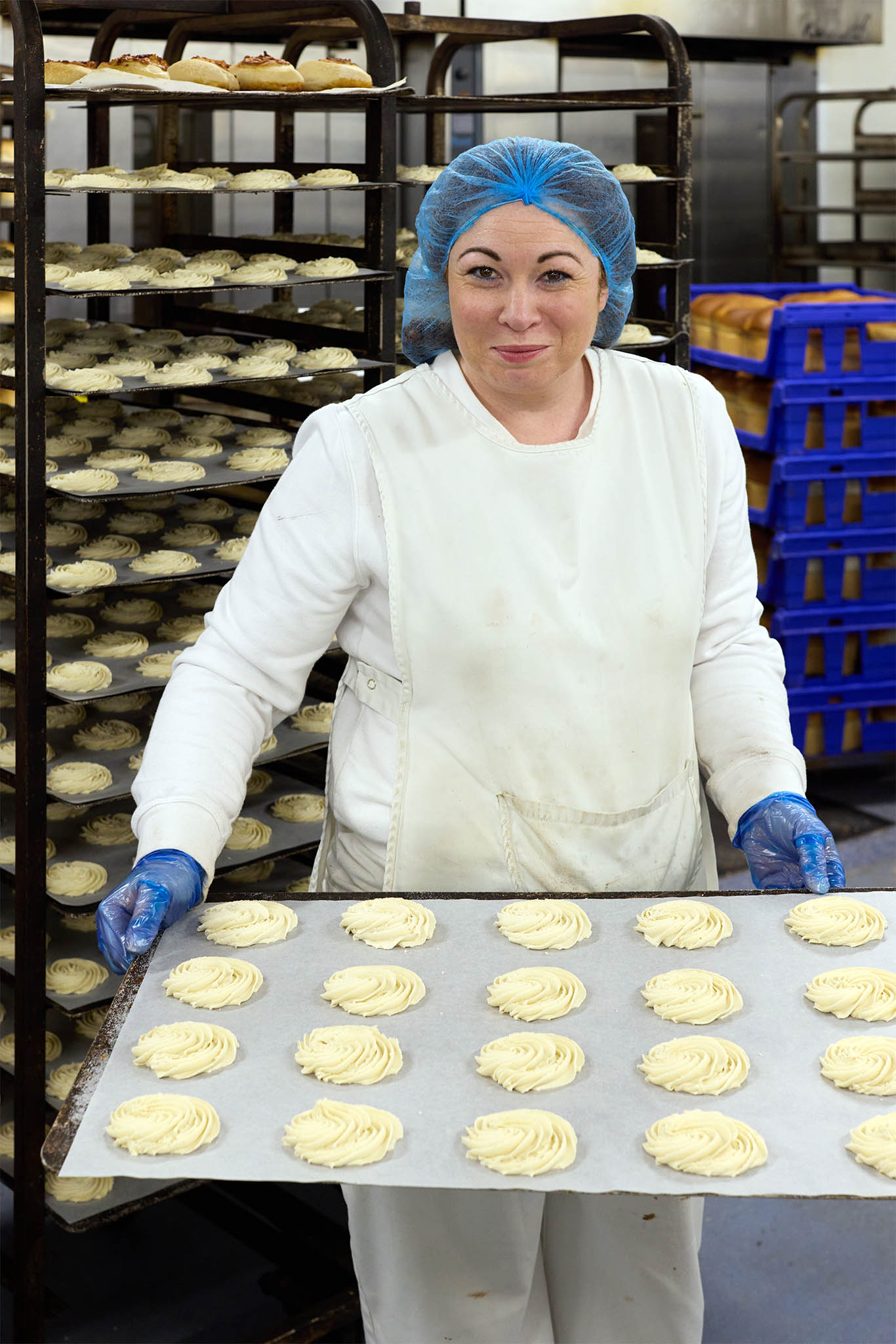 Janes Pantry female baker employee holding tray of piped biscuits