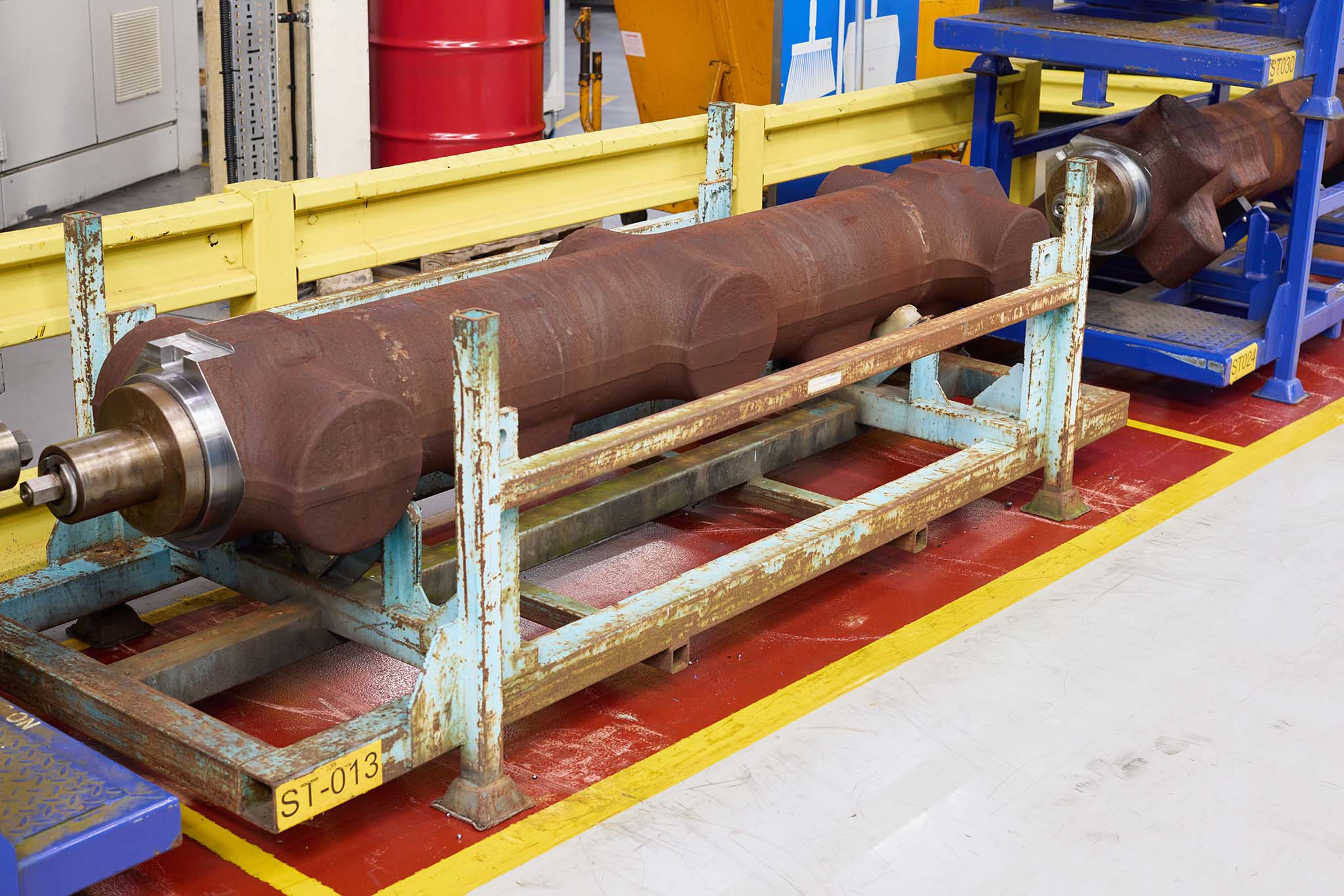 Safran Landing Systems large factory machinery blue yellow red stand holding large pipe rusty