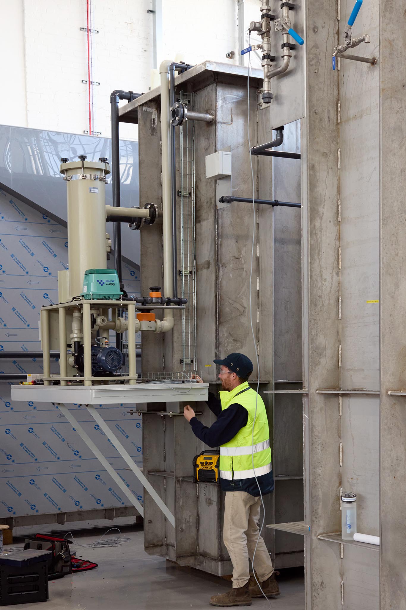 Safran Landing Systems employee in high vis jacket outside factory building surrounded by tall metal platform and structure