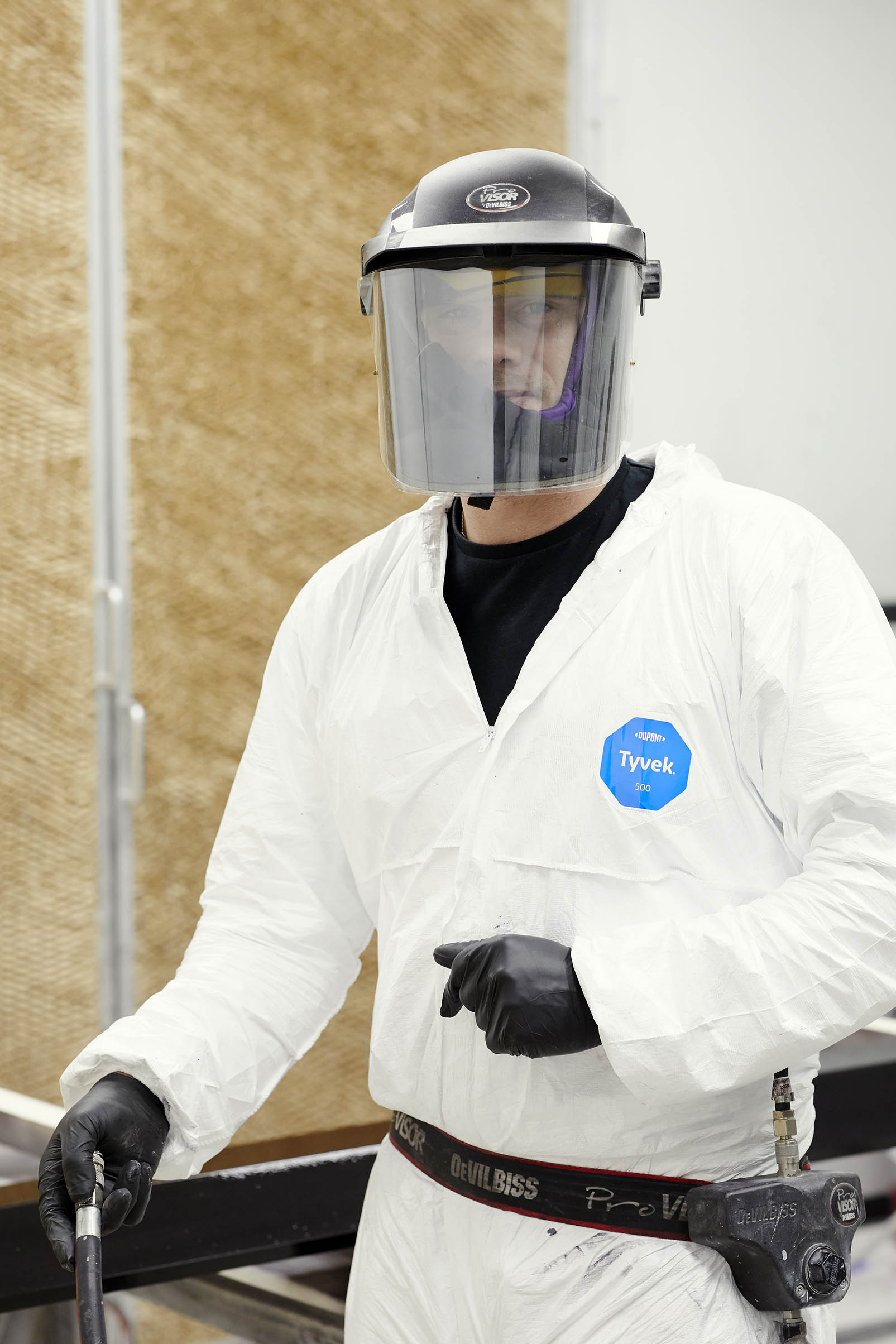 Beck employee in full white suit and protective headgear and maskr
