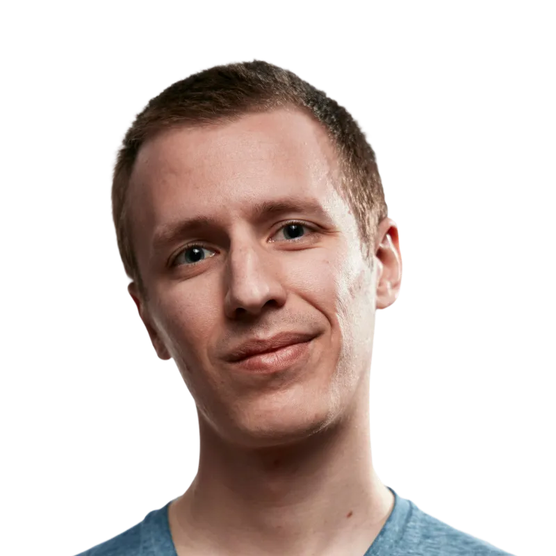 Young man with short light brown hair wearing a blue shirt, smiling softly against a transparent background.