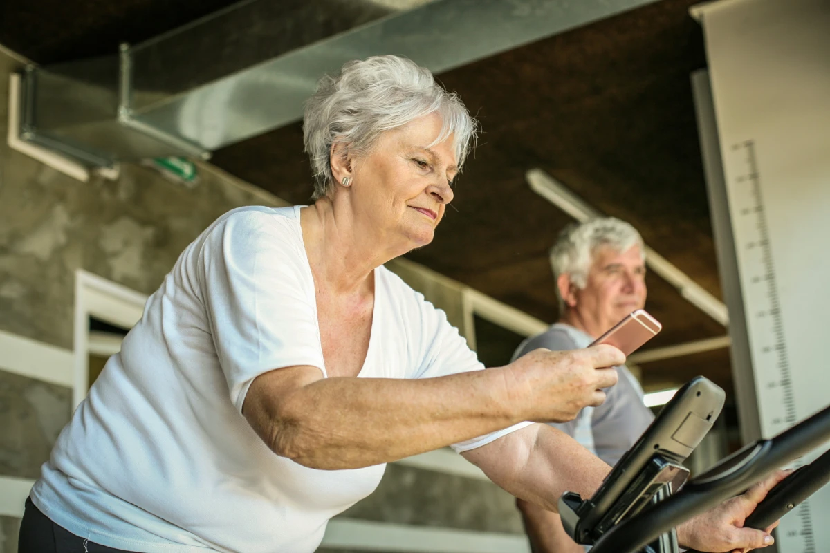 oudere vrouw aan het sporten op een fiets
