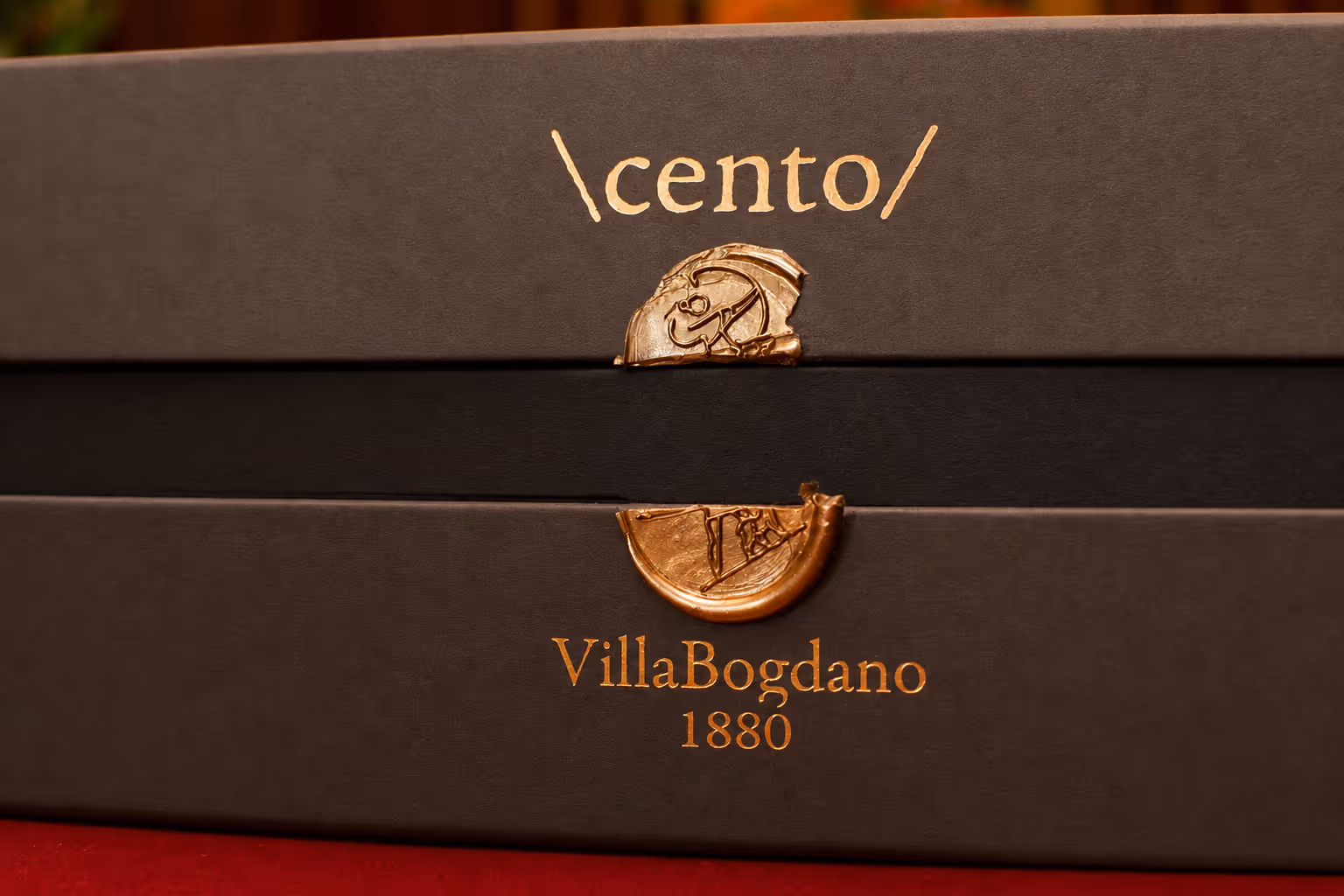 Close-up of black boxes labeled \cento/ and VillaBogdano 1880 with gold embossed seals and text.