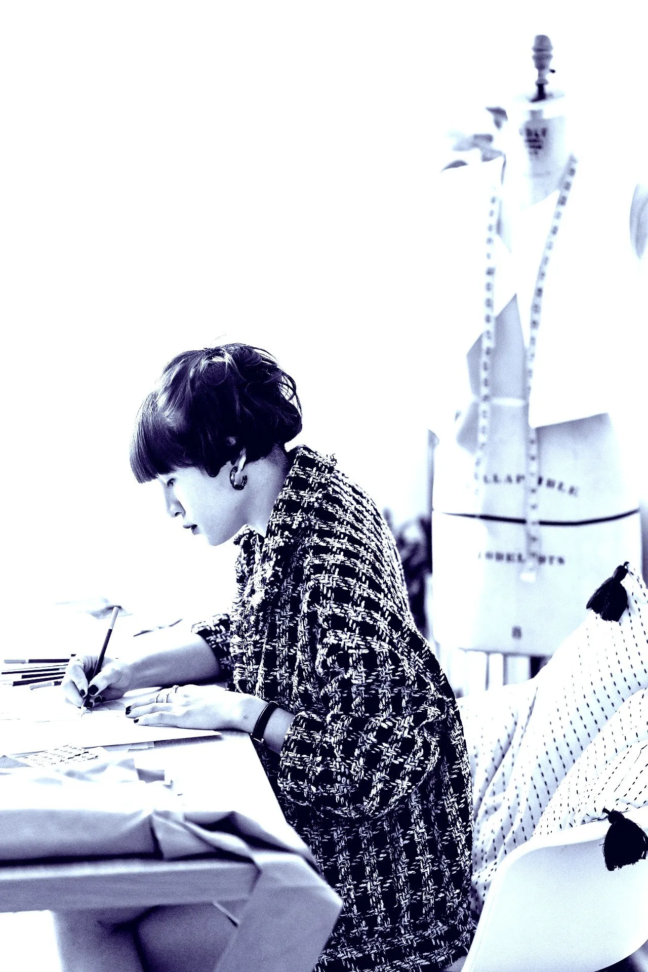 Woman with short hair writing at a desk