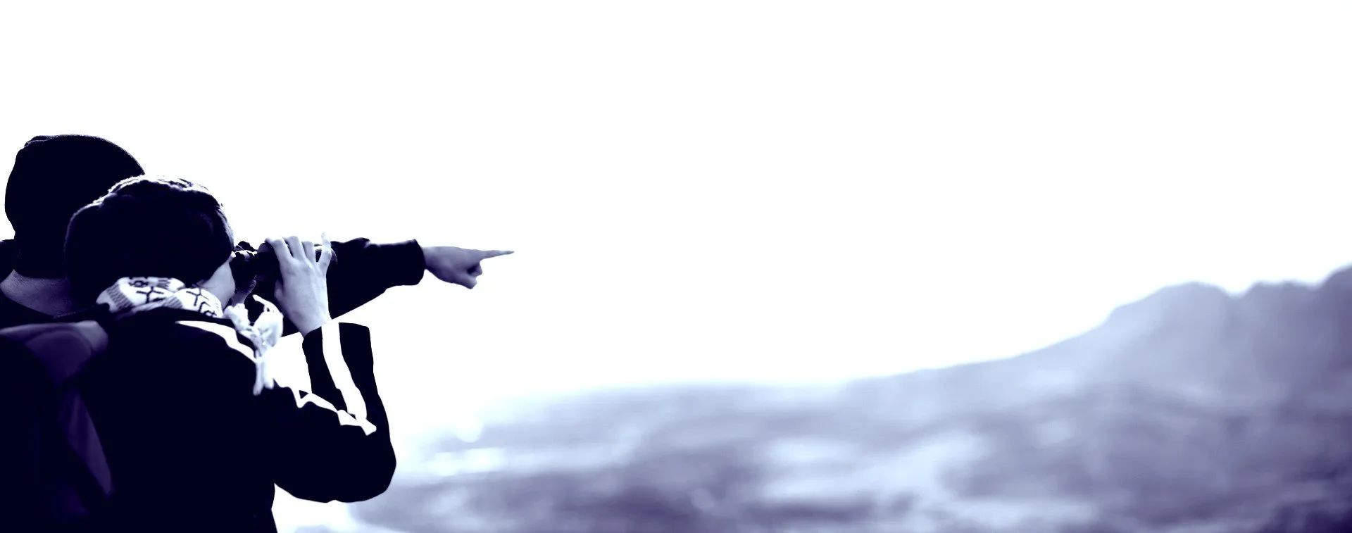 Two people looking into the distance at a mountain