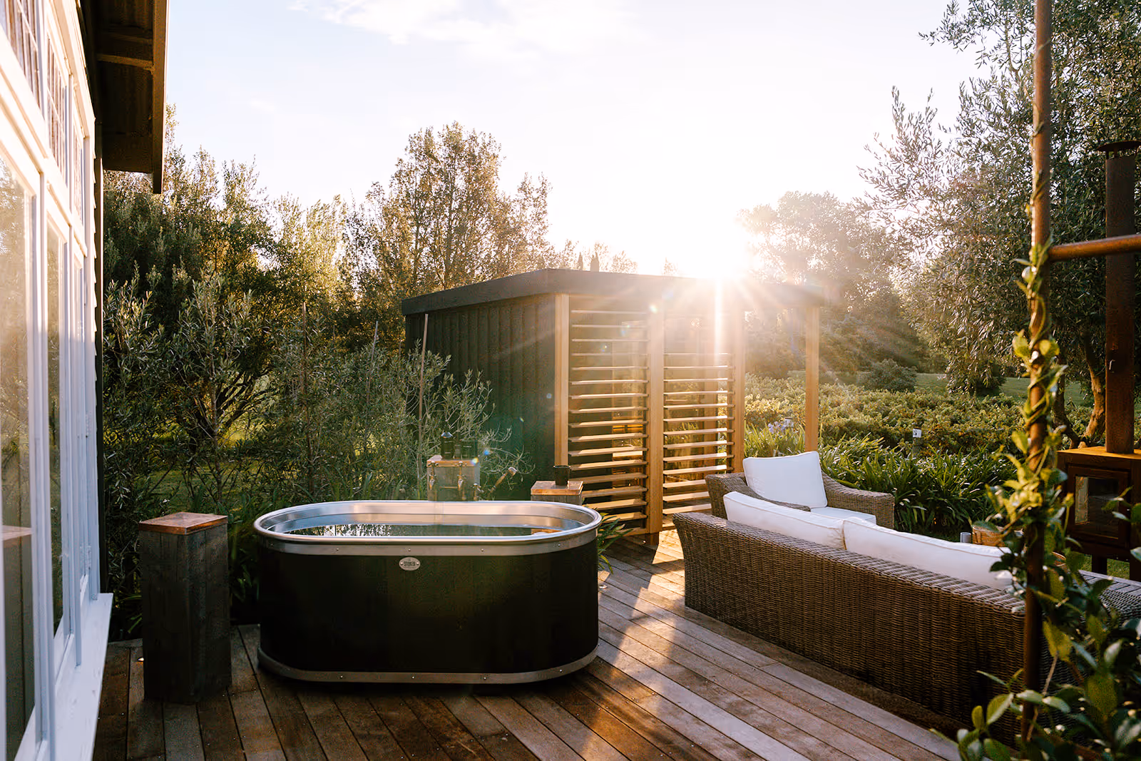 Sunrise over an outdoor area with a sauna and ice bath