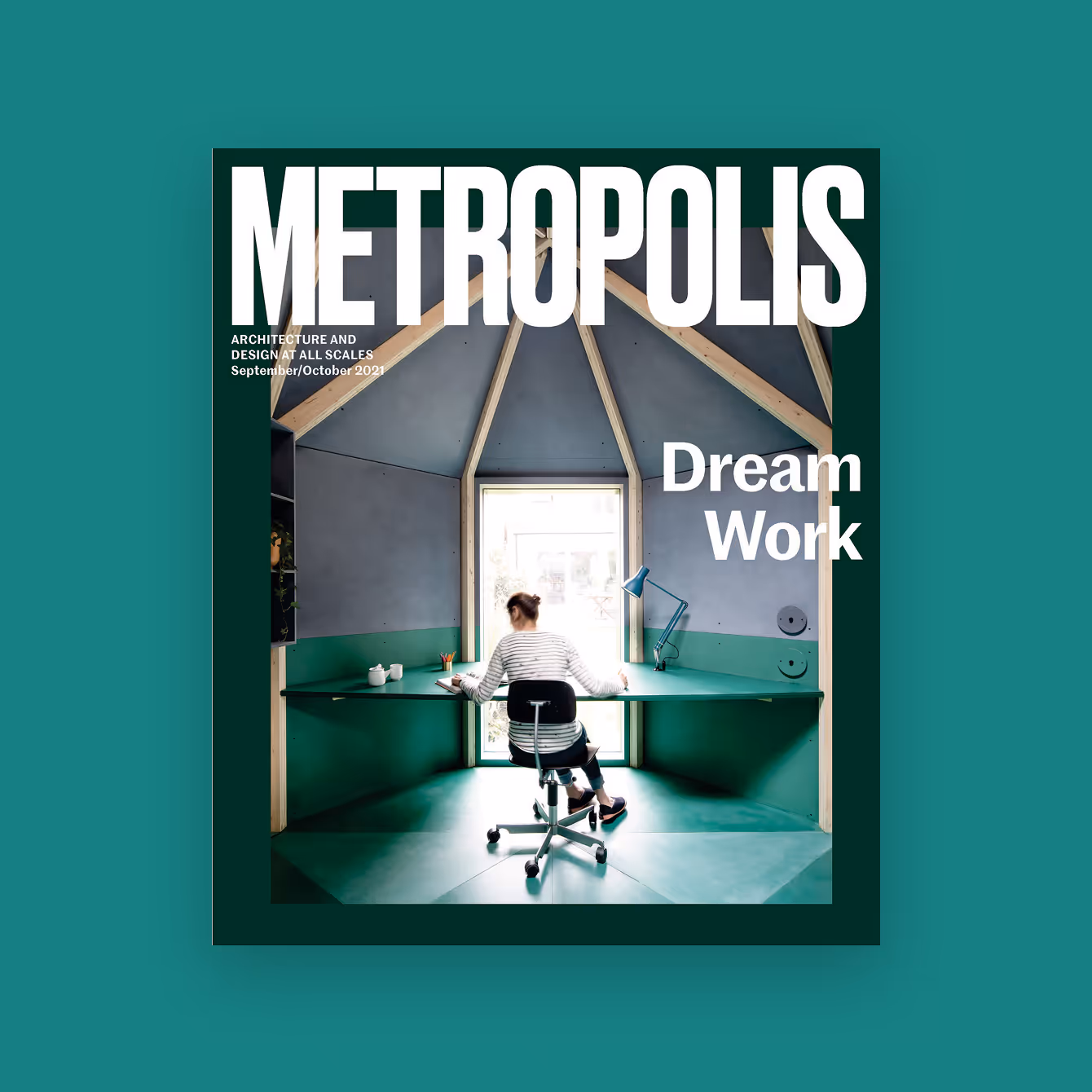 Magazine cover of Metropolis showing a person working at a desk inside a small, modern, house-shaped workspace with wood beams and a large window.