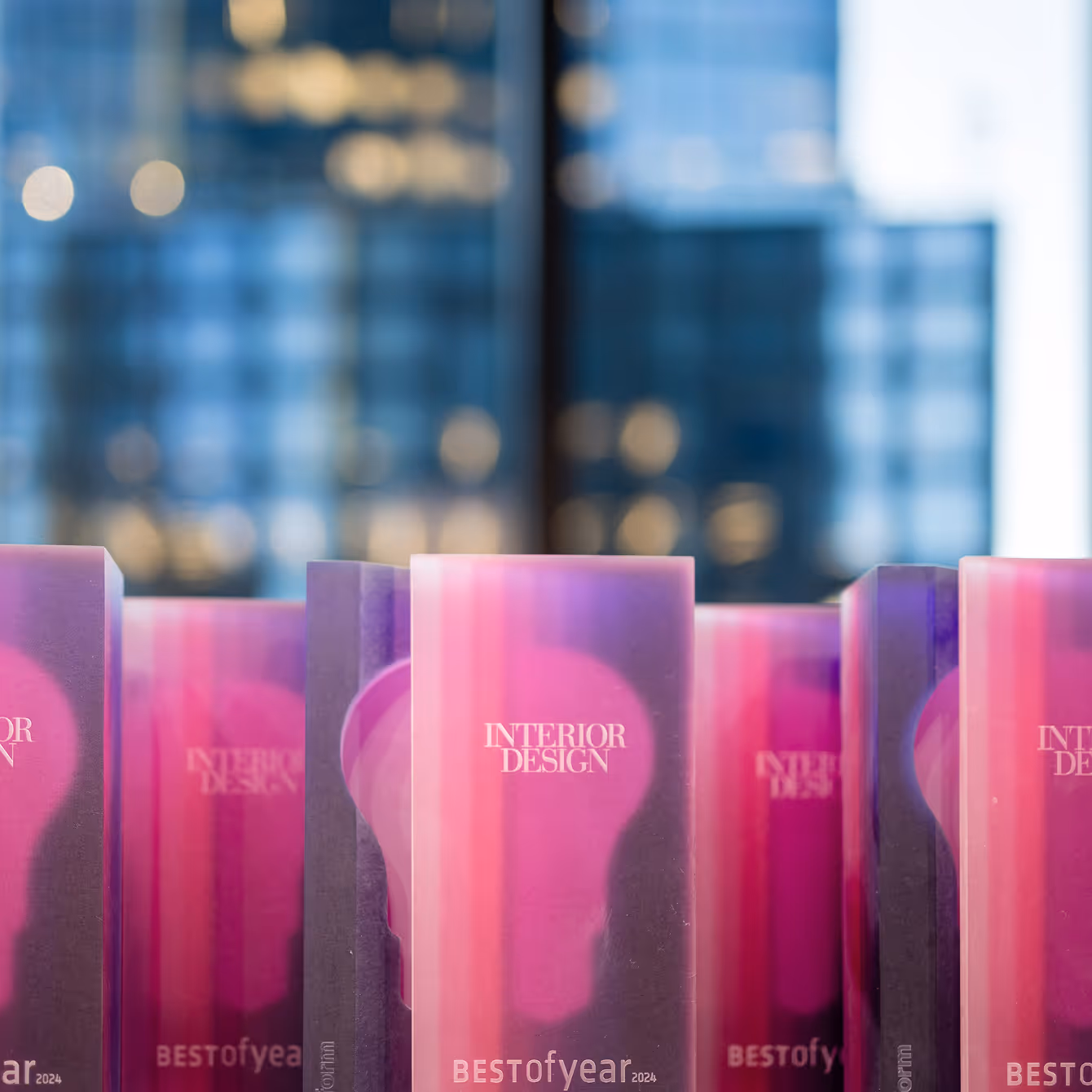Interior Design Best of Year 2024 awards with a pink light bulb design on translucent plaques.