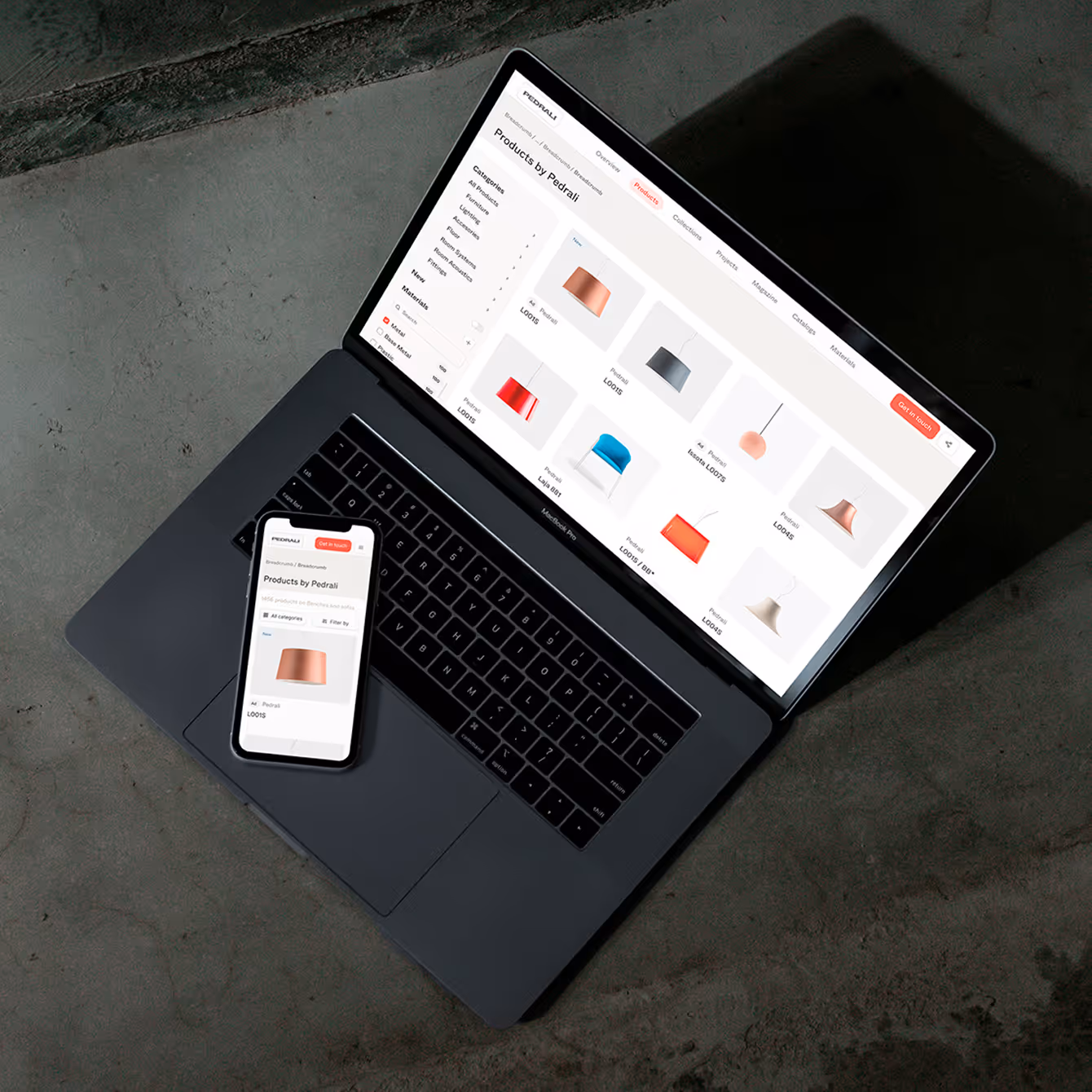Laptop and smartphone displaying Pedrali product listings on a dark textured surface.