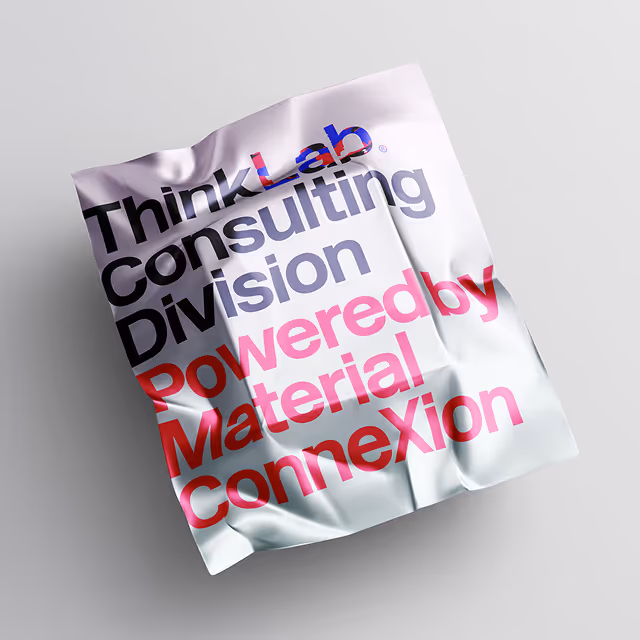 Crumpled white paper sheet with the text 'ThinkLab Consulting Division Powered by Material Connexion' in black, blue, grey, and red fonts.