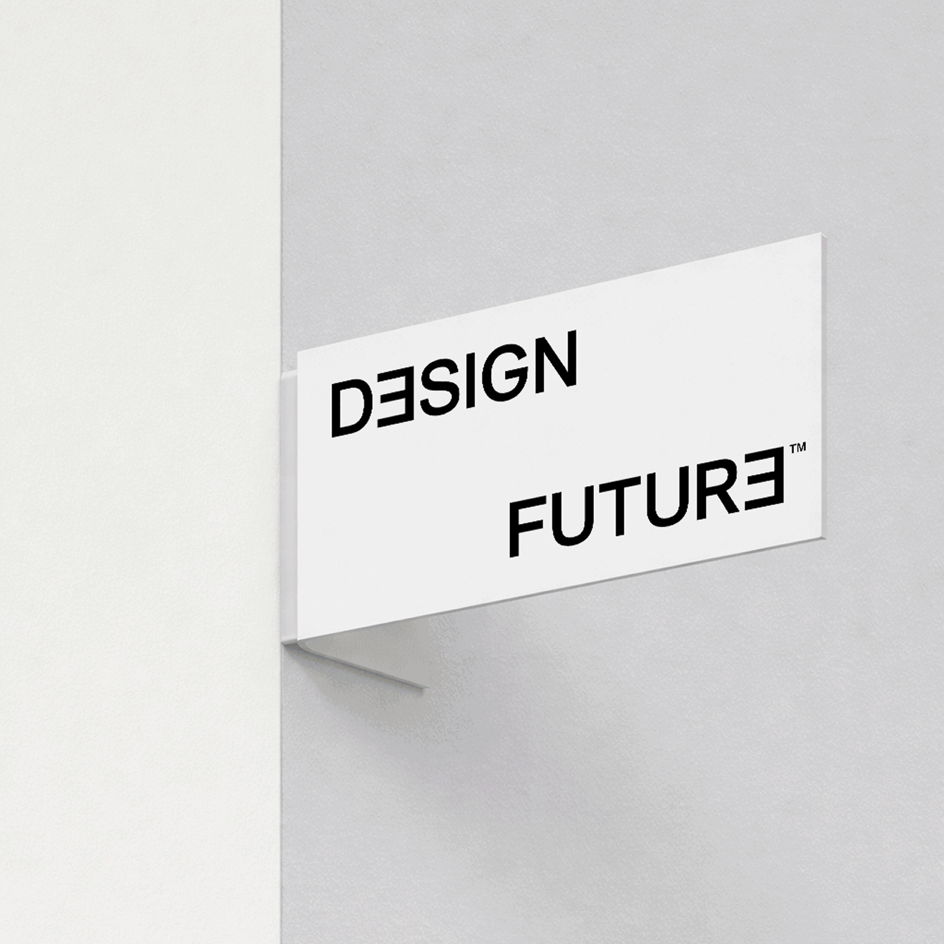 White corner sign on a wall with black text reading DESIGN above FUTURE, both words stylized with reversed letters.