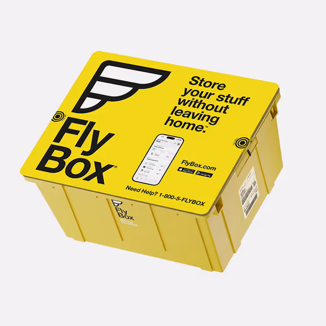 Yellow FlyBox storage container with a lid displaying the FlyBox logo, a smartphone image, and text promoting storing items without leaving home.