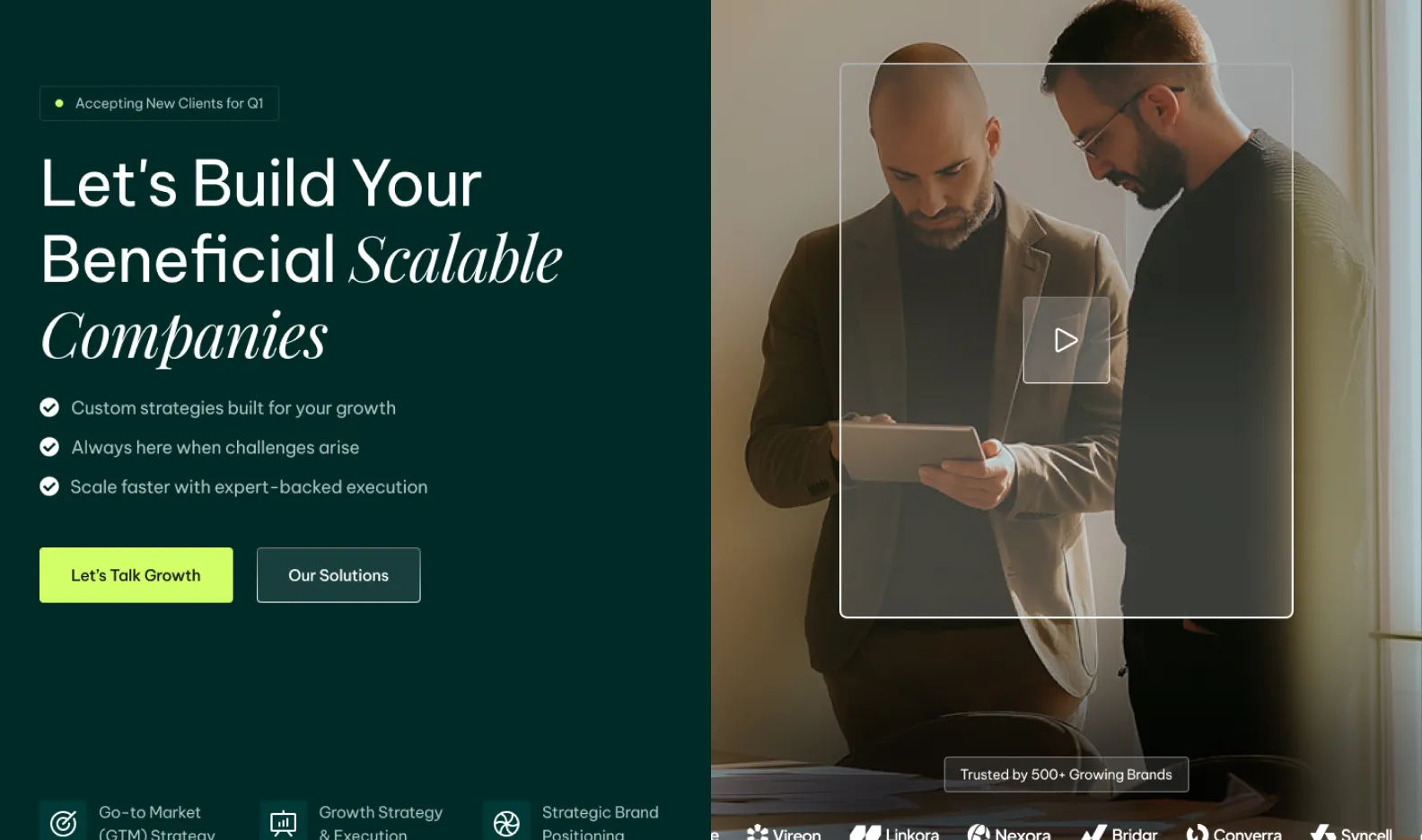 Two men looking at a tablet together in an indoor office setting with sunlight coming through a window.