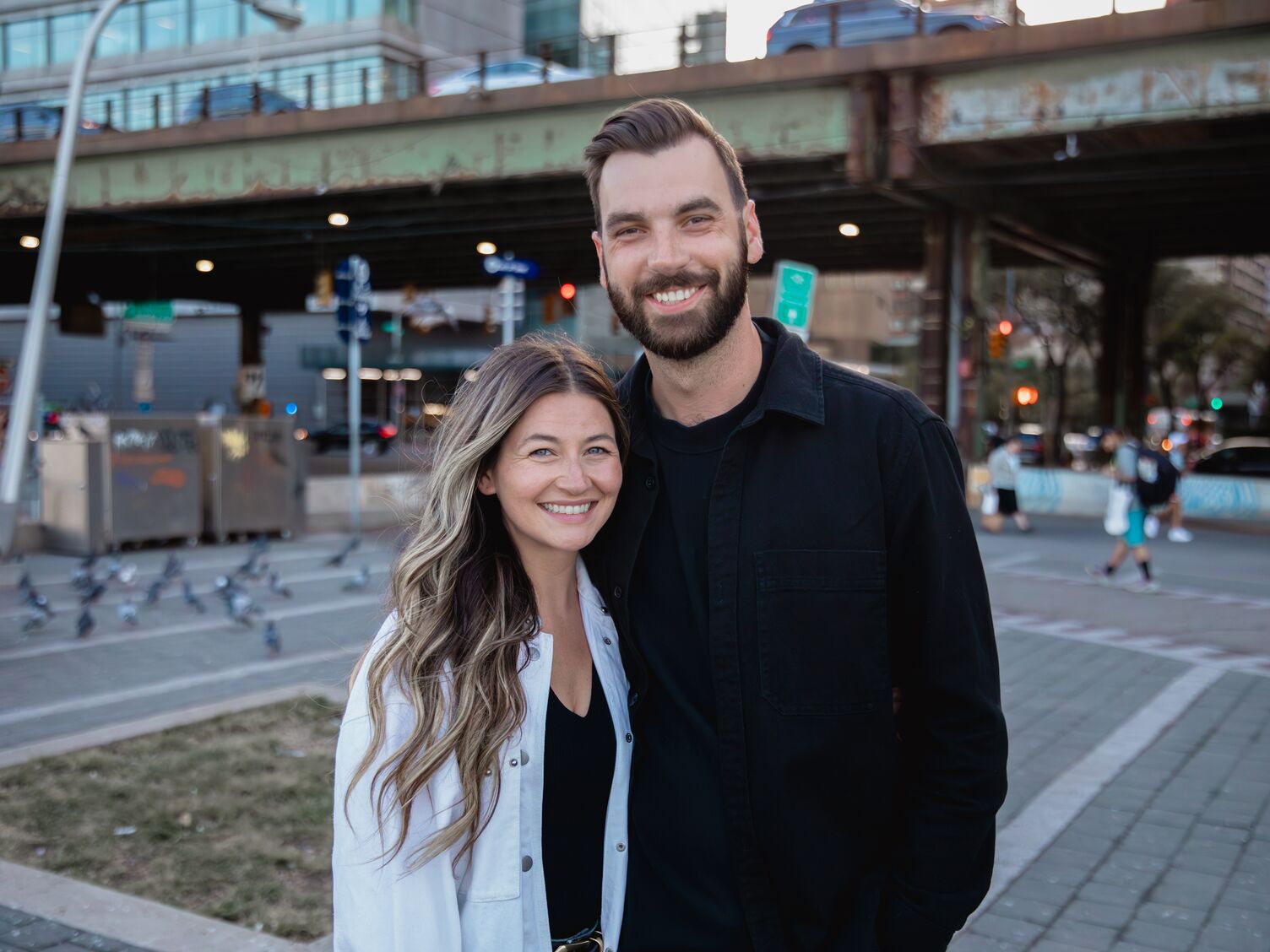 A couple smiling together in front of a train station in New York City