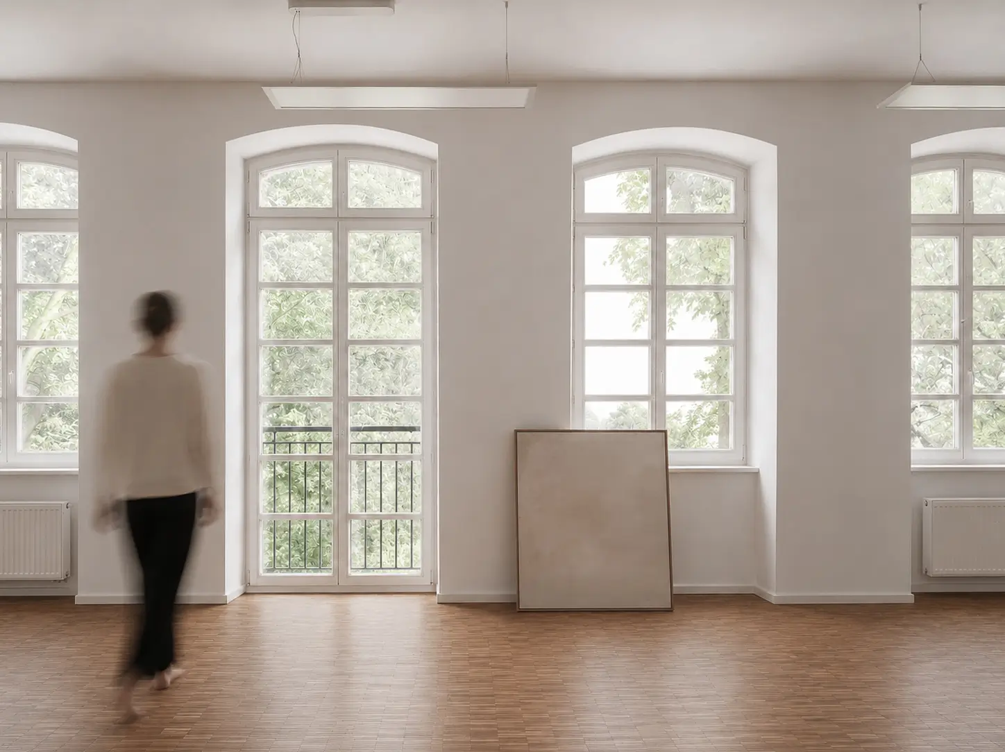 A light-filled stairwell with a tall arched window at The Hinterhaus