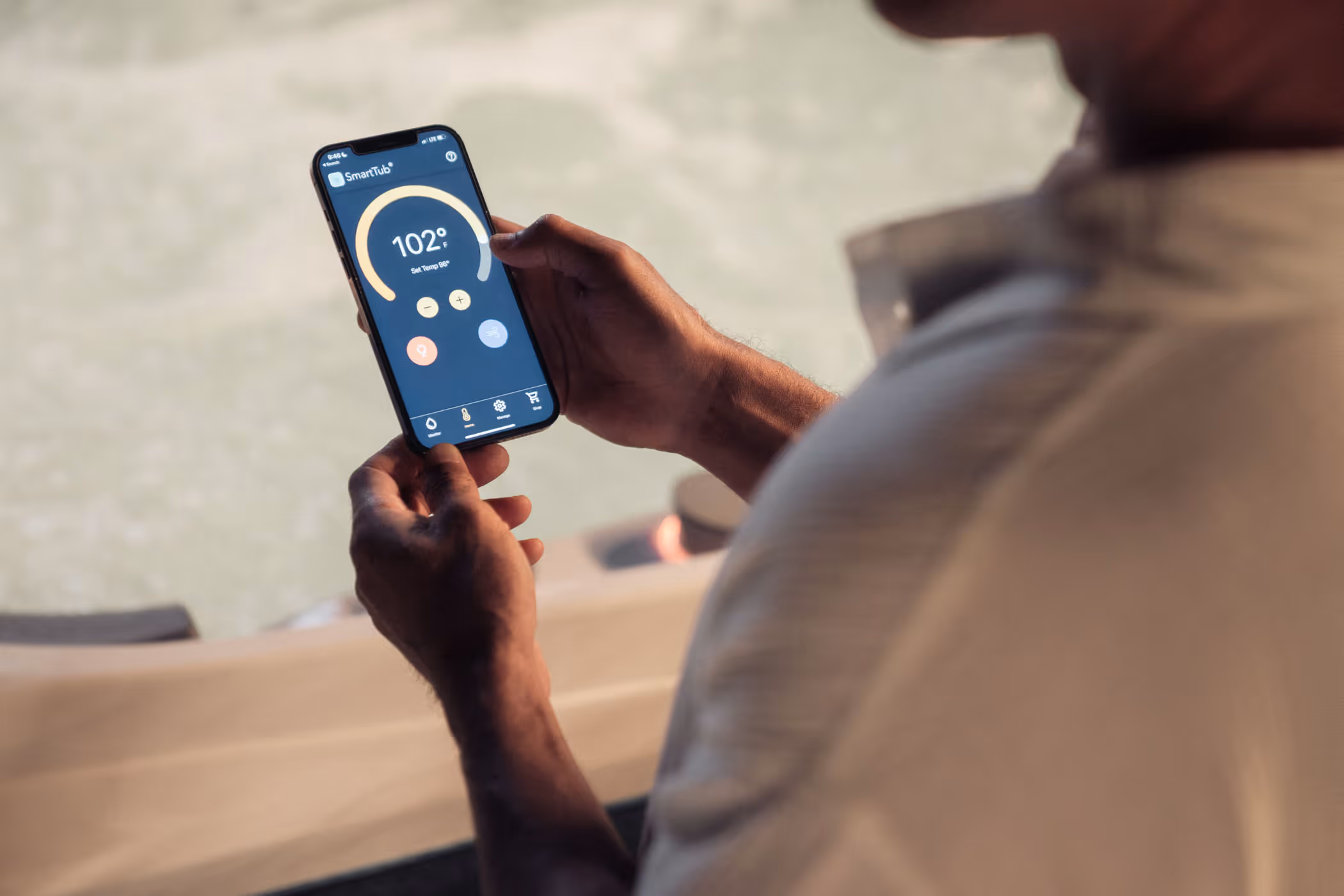 man controlling hot tub with cell phone