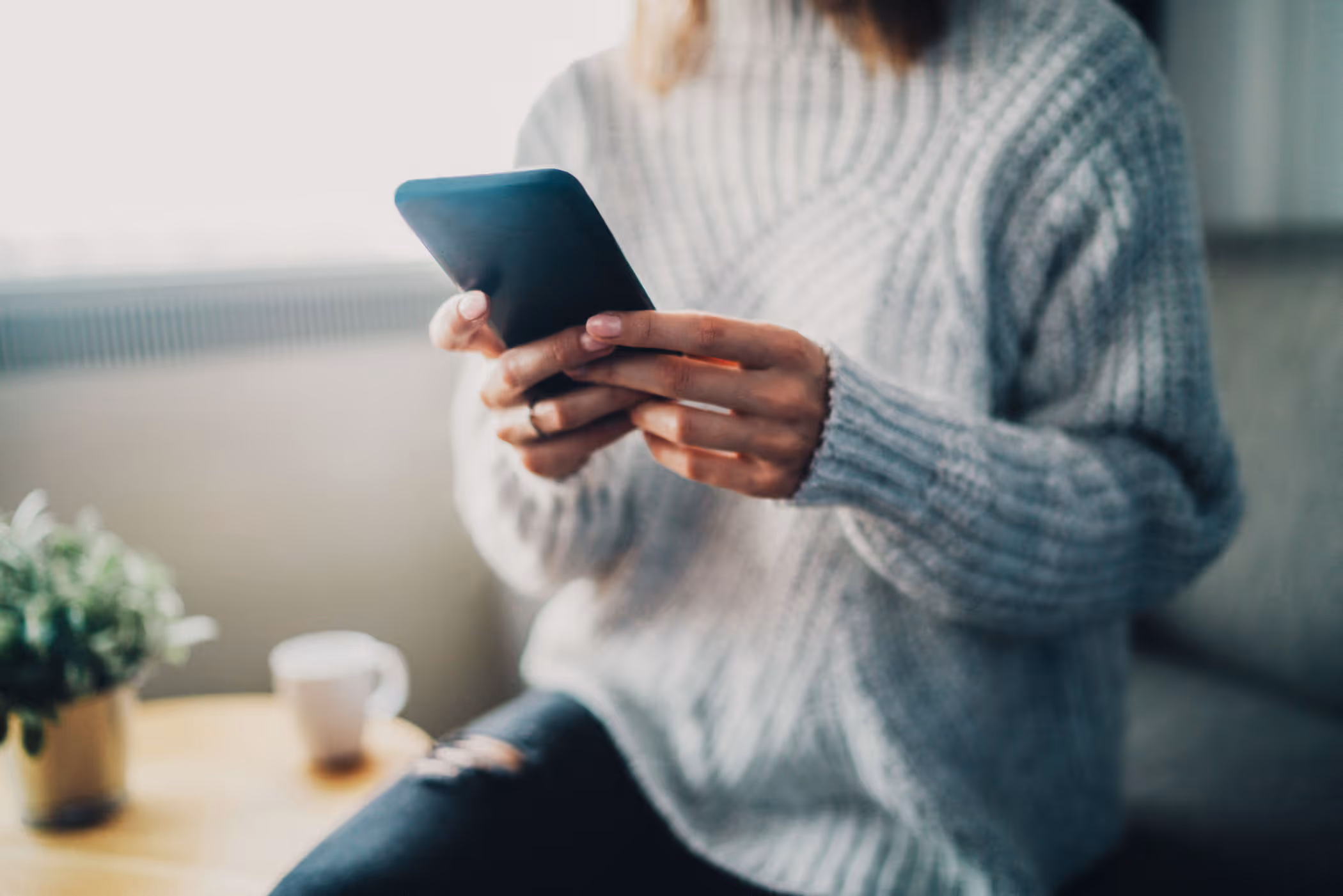 woman in a sweater with mobile phone