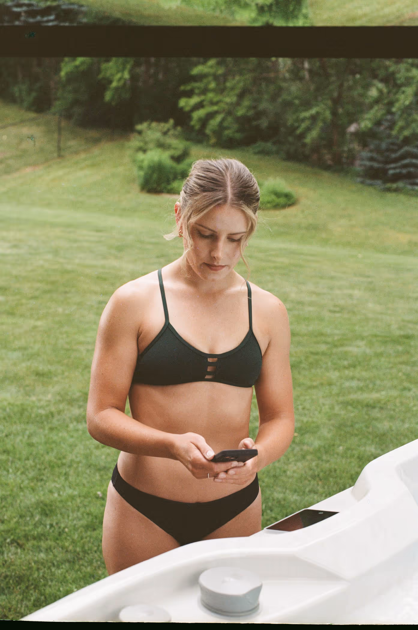 woman in swim suit with cell phone