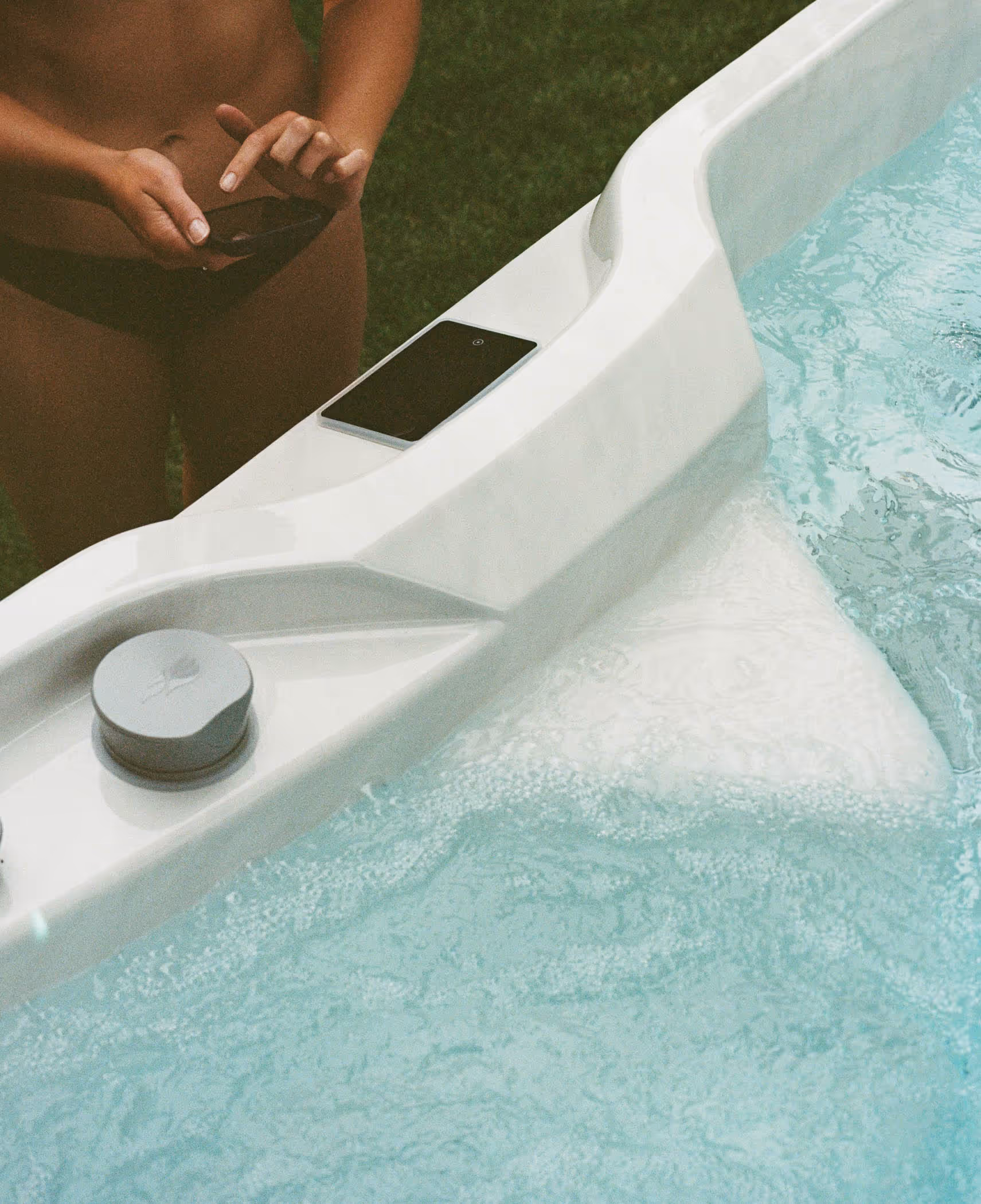 woman looking at her smart phone next to hot tub