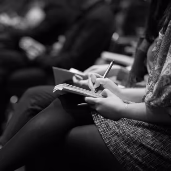 a person sitting down writing on a book