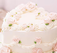 Pastel blanco decorado con rosas de glaseado en tonos pastel.