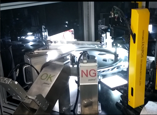 Industrial optical sorting machine with conveyors labeled OK and NG, and a yellow JANPO safety sensor.