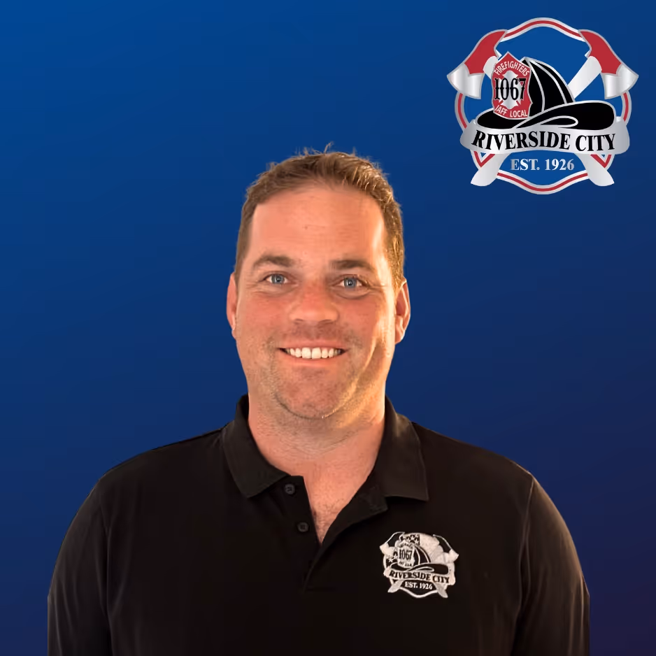 Smiling man wearing a black polo shirt with Riverside City Firefighters logo on a blue background.