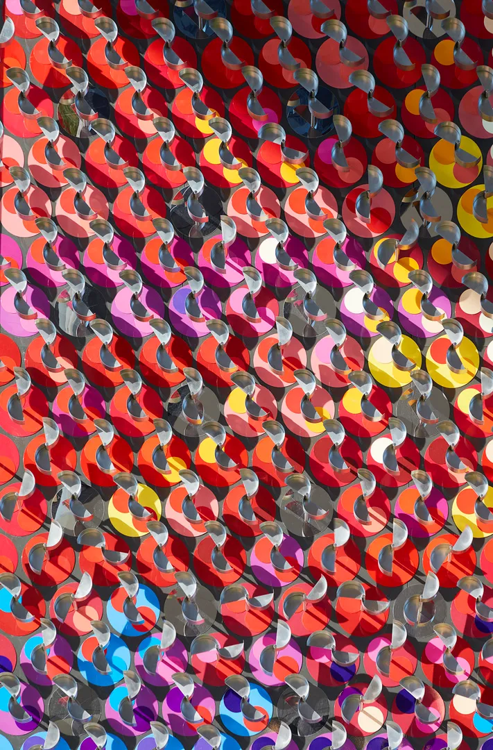 Close-up of colorful overlapping circular discs with metal loops, creating a vibrant geometric pattern.