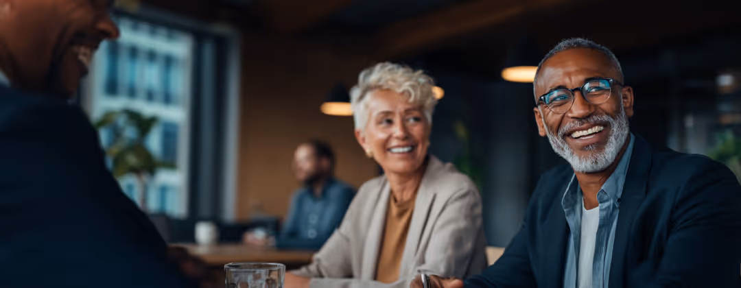 Two smiling professionals in a business meeting at an office.