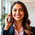 Smiling woman with long dark hair, wearing a blazer and holding a phone to her ear.