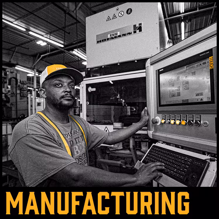 Man in safety gear operating industrial machinery with control panel 