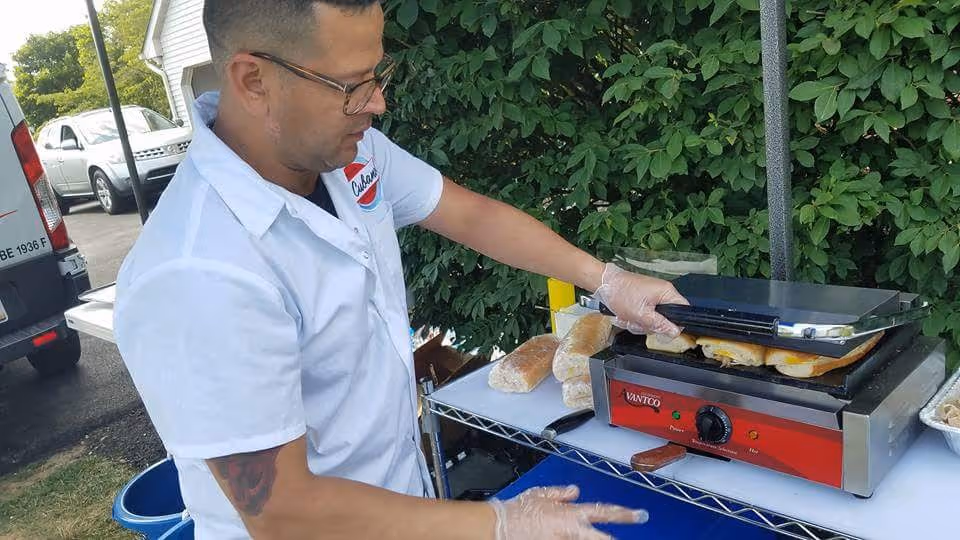 Chef preparing fresh Cuban sandwiches at catering event
