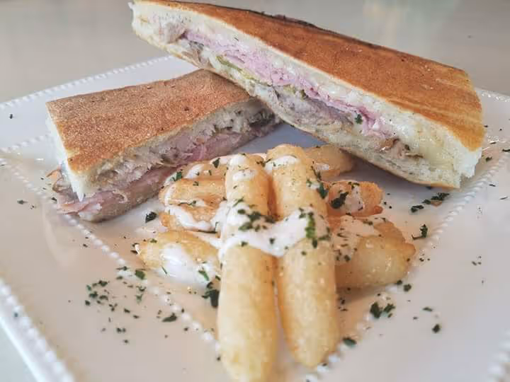 Cuban sandwich and yuca fries served on plate at catering event