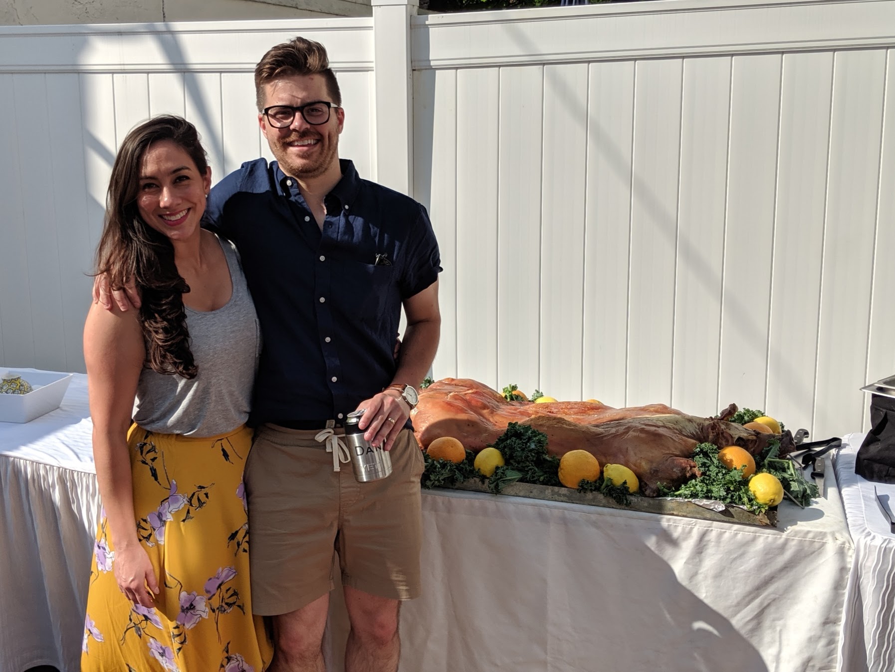 Event hosts posing with El Cubano Catering whole pig roast