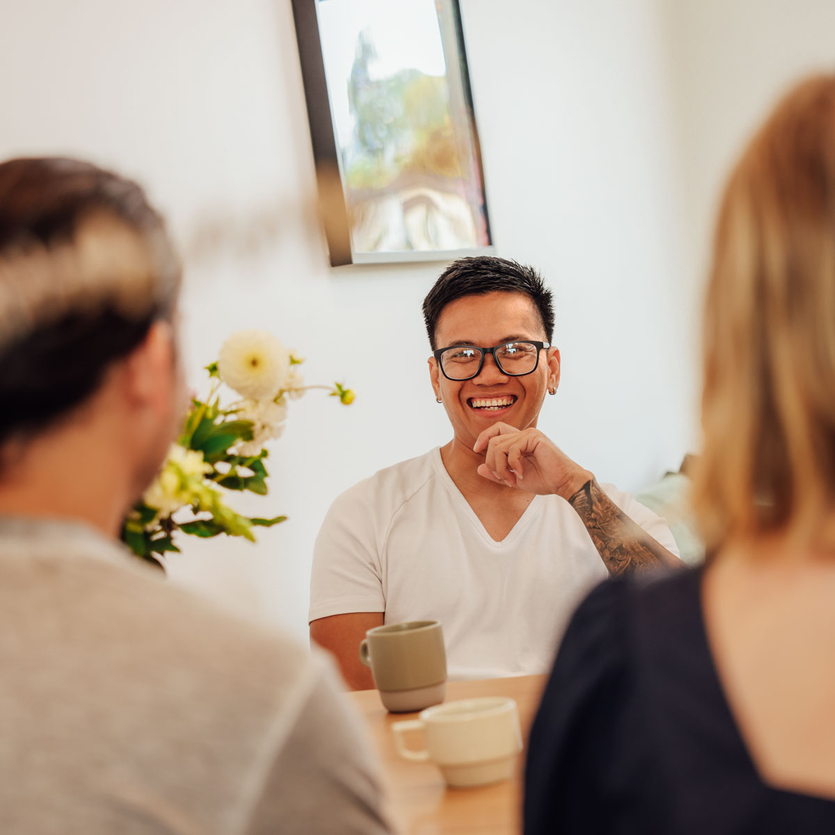 Young couple moving into their new home, moving boxes into an empty living room, excited with their first home, all possible through Aera.