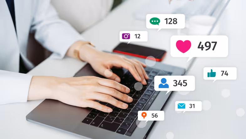 A person's hands typing on a laptop keyboard, surrounded by various social media notification icons including likes, messages, and comments. The scene suggests engagement with online content.