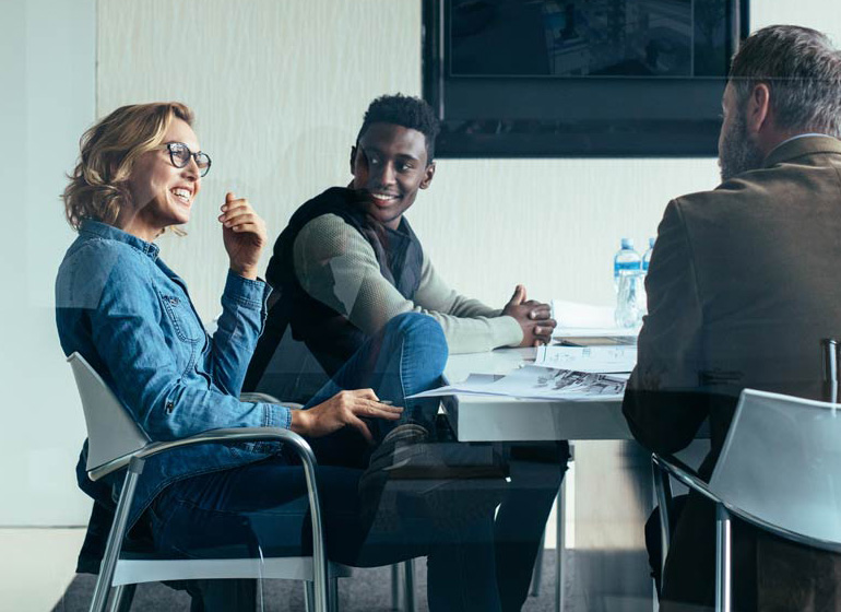 Two men and a woman having a pleasant meeting conversation