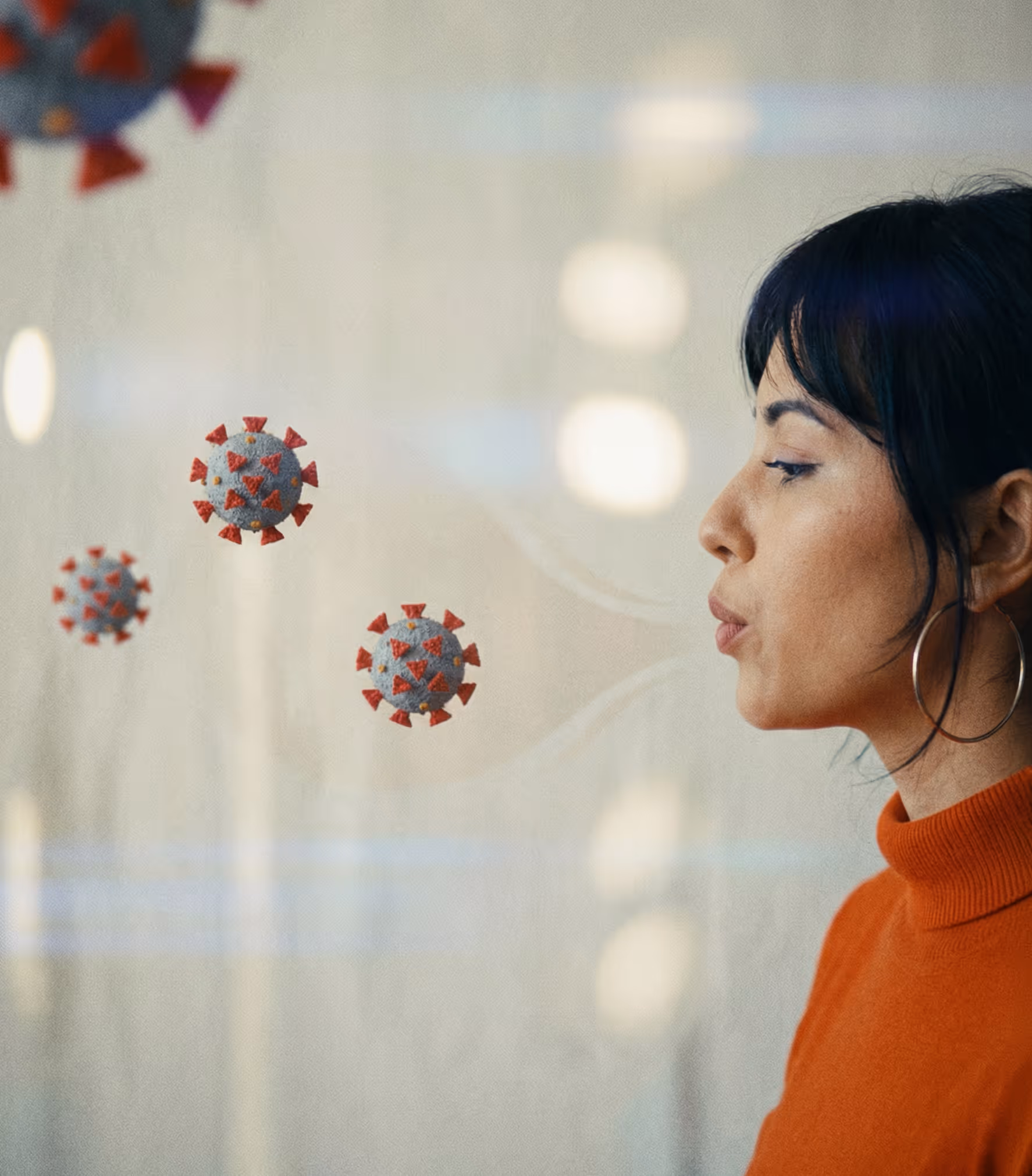Woman with glasses sitting on a brown couch in a stylish living room, working on a laptop.