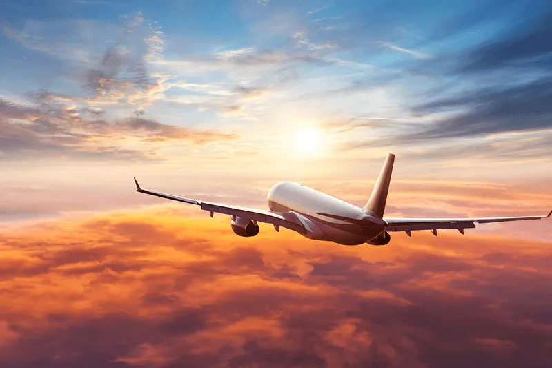 plane flying at sunset