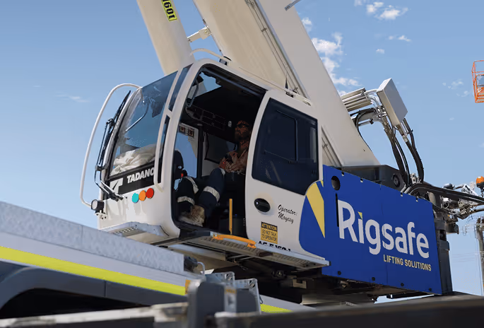 Operator sitting inside a Tadano crane cab branded with Rigsafe lifting solutions.