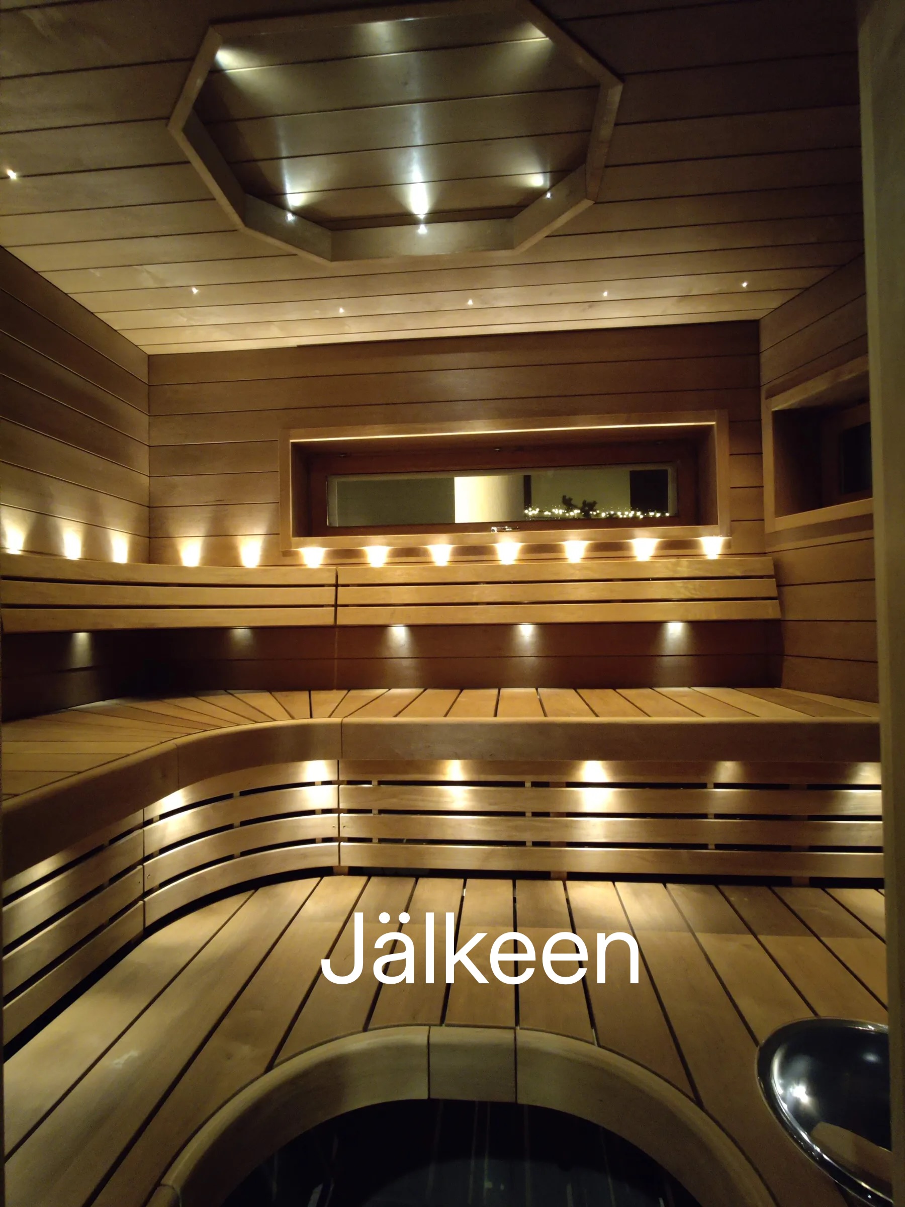 Puinen sauna, jossa on penkit, valaistus ja ikkuna.