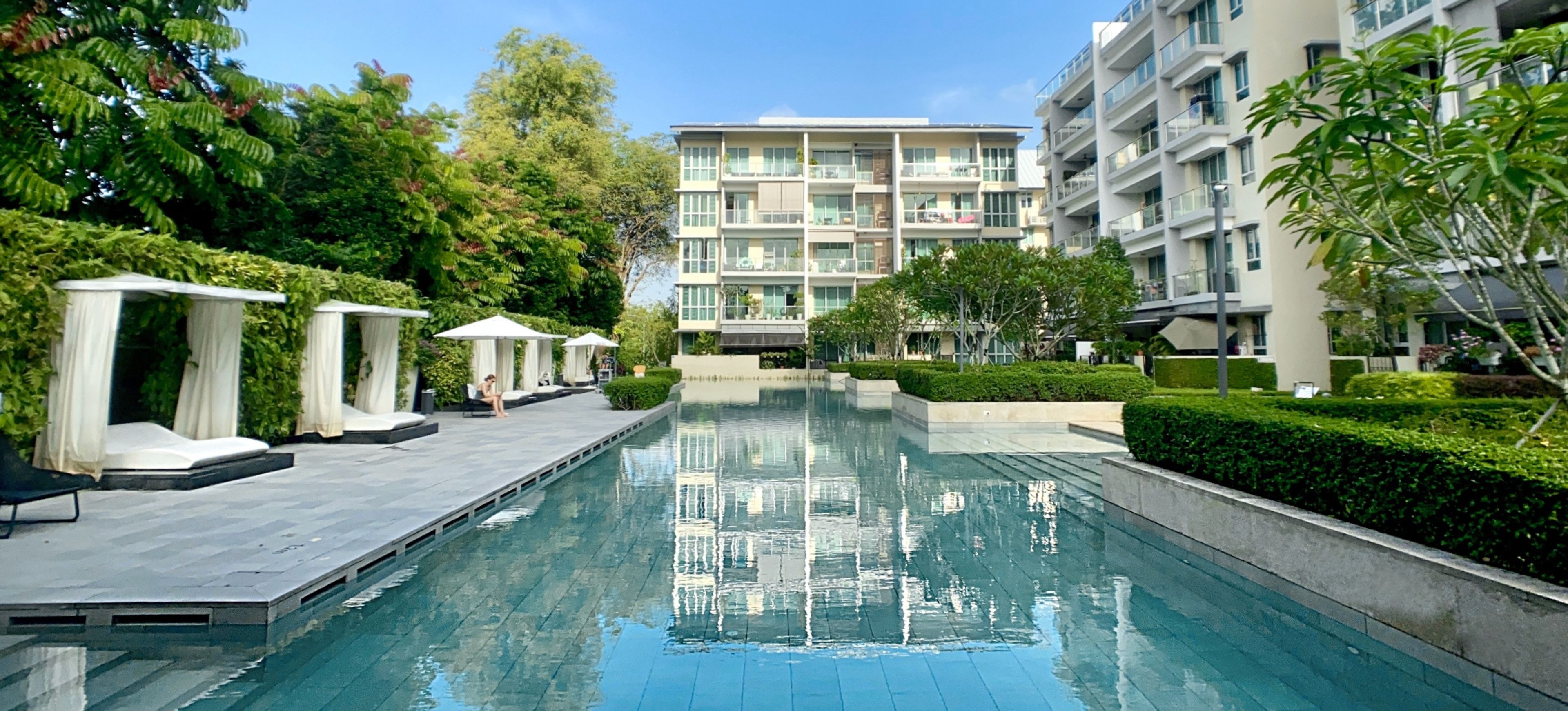 The Glyndebourne condominium 50-metre lap pool, with spacious pool decks lined with lounge chairs and cabanas. Residential buildings rise in the background.