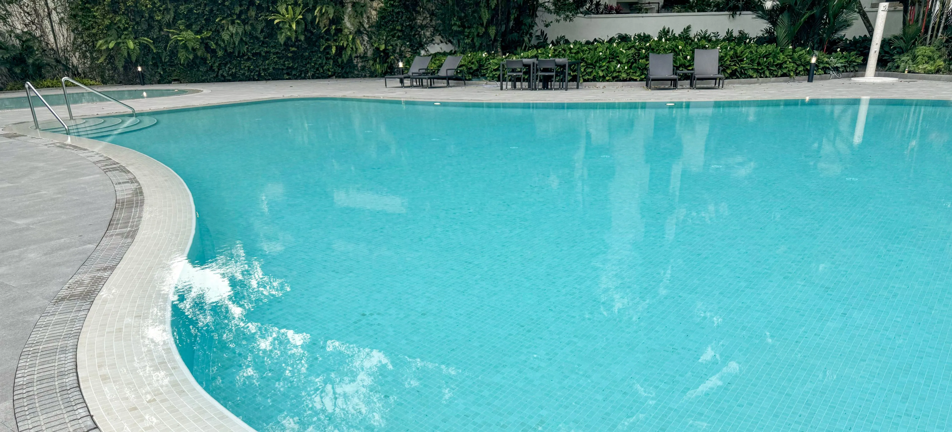 The Arcadia condominium swimming pool, with curved pool edges and gutters.