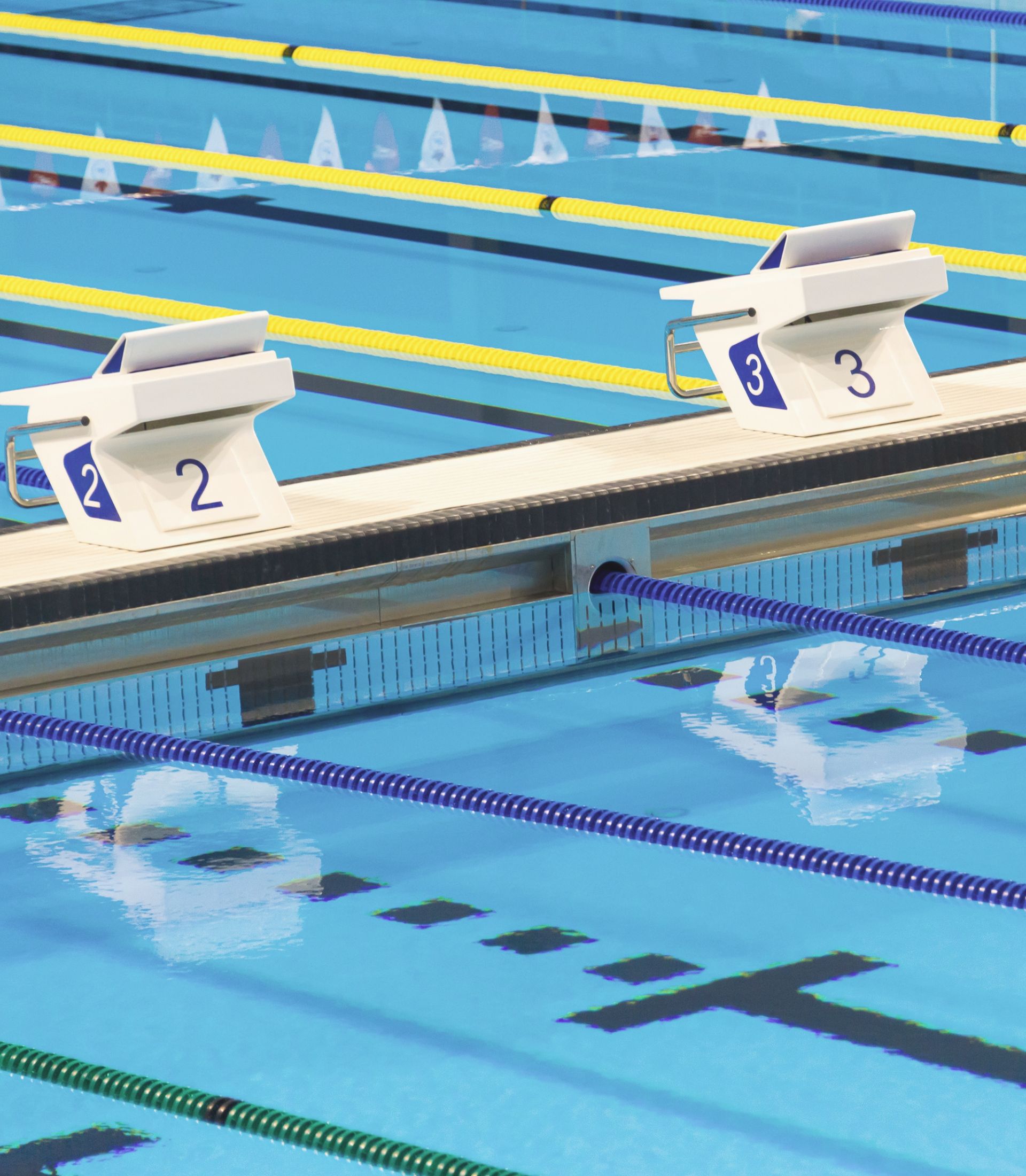 Numbered starting blocks are placed atop a bulkhead, dividing the swimming pool up into two section for various activities.