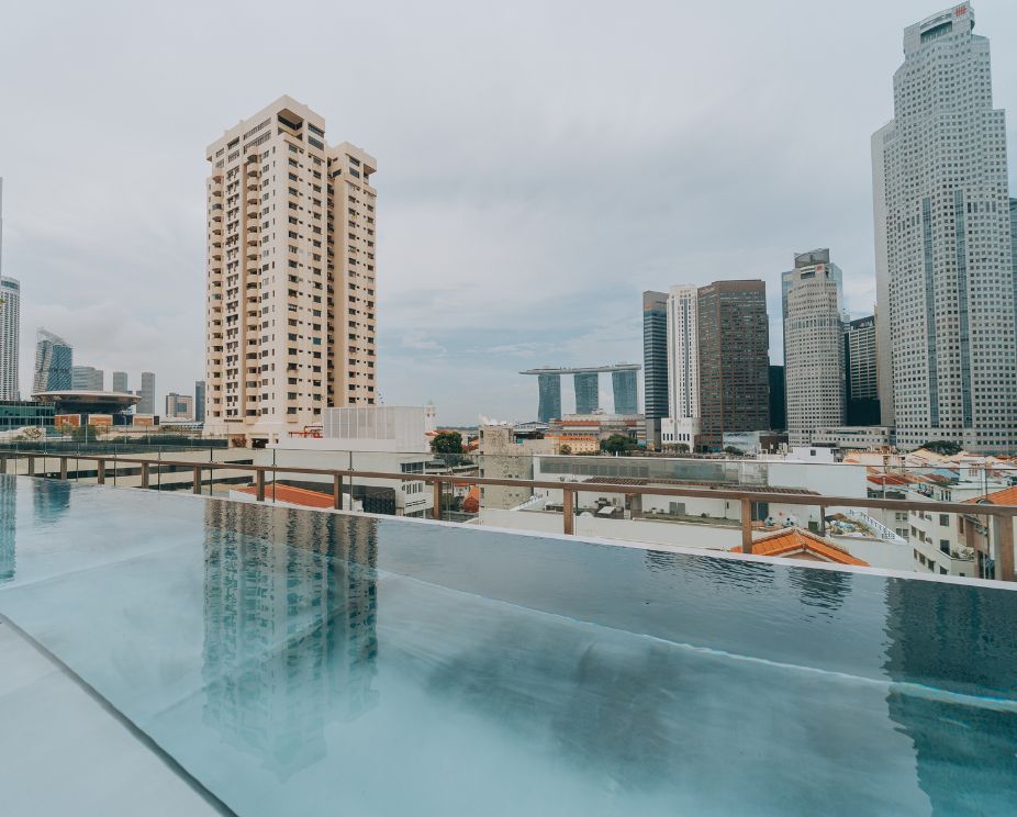 The stainless steel lap pool at 21 Carpenter hotel, facing towards Singapore city's skyline.