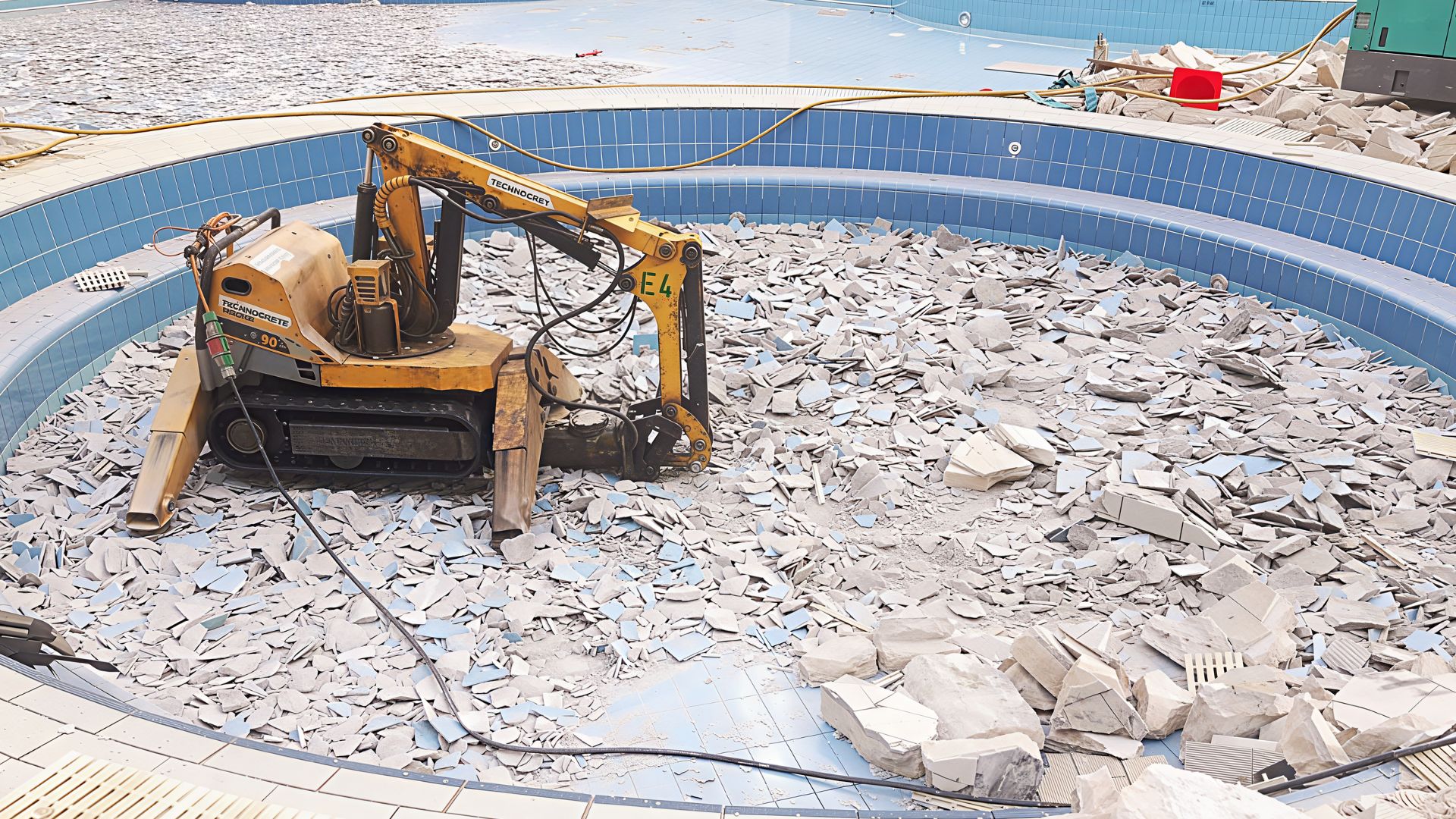 A demolition robot demolishes the old swimming pool at Costa Rhu condominium, in preparation for renovation works by Innovez Engineering.